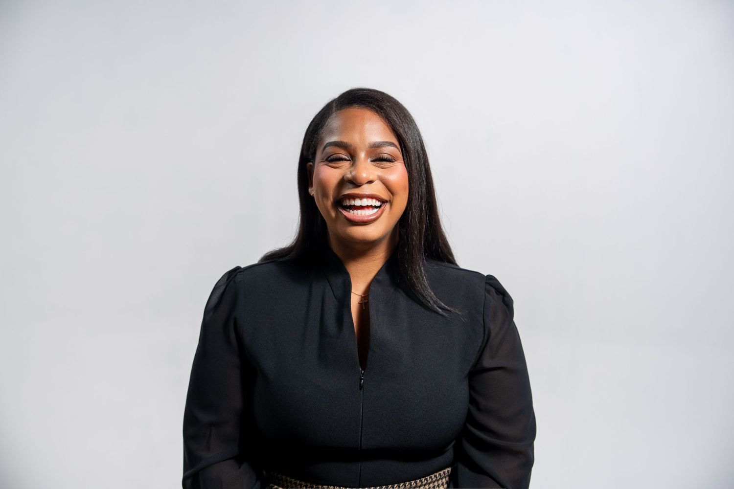 Female entrepreneur smiling in black outfit during studio branding session