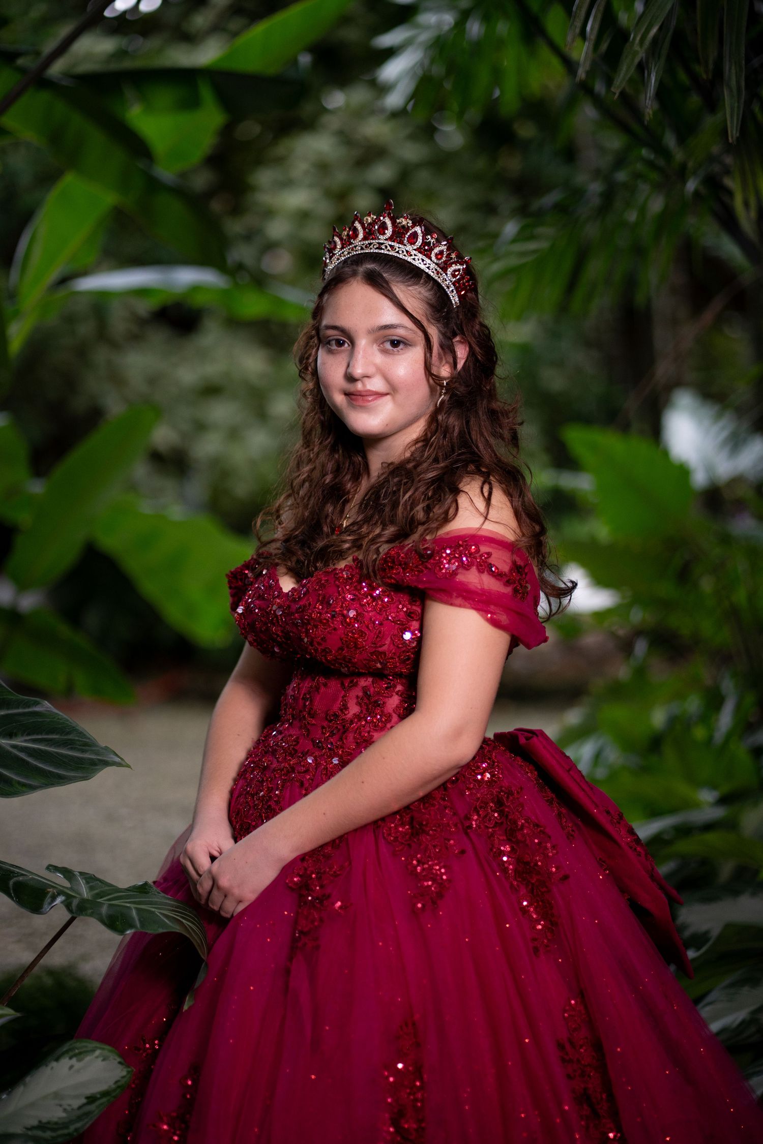 Quinceañera portrait at RF Orchids featuring a young woman in a red gown, photographed with a polished, editorial approach in South Florida.