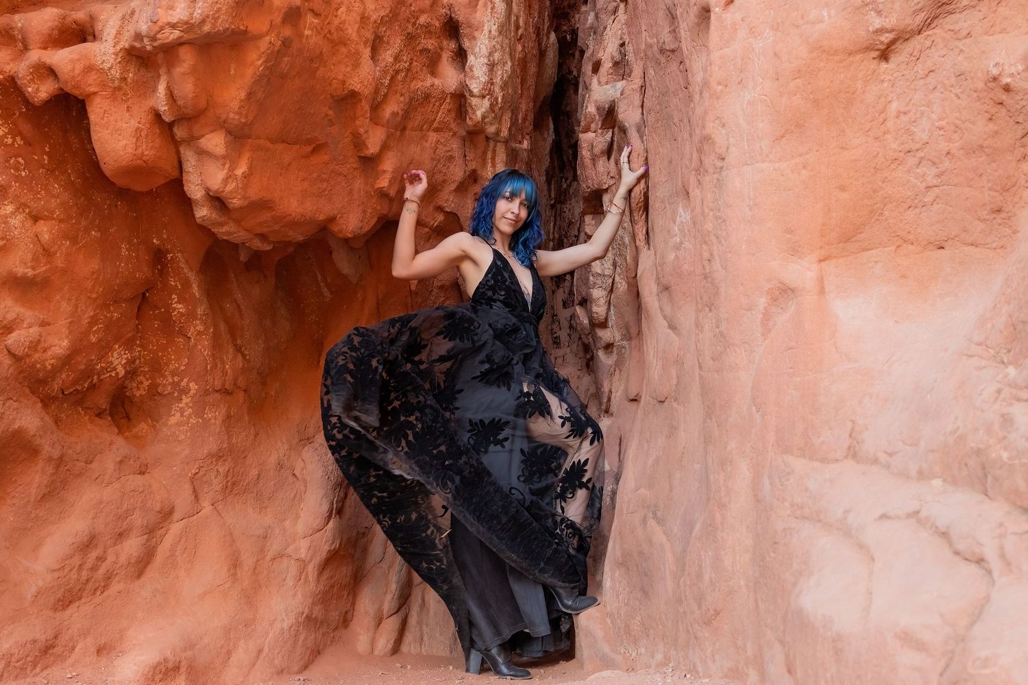 Dramatic movement – a woman twirls in a sheer black gown against the stunning red canyon walls of Colorado.