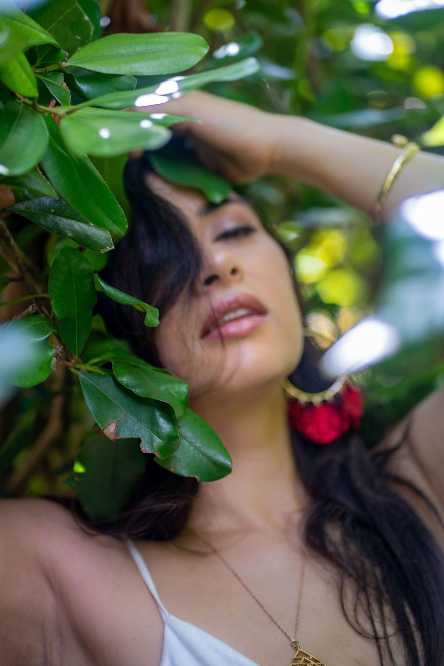 Miami portrait photography of woman posing among green leaves with natural light