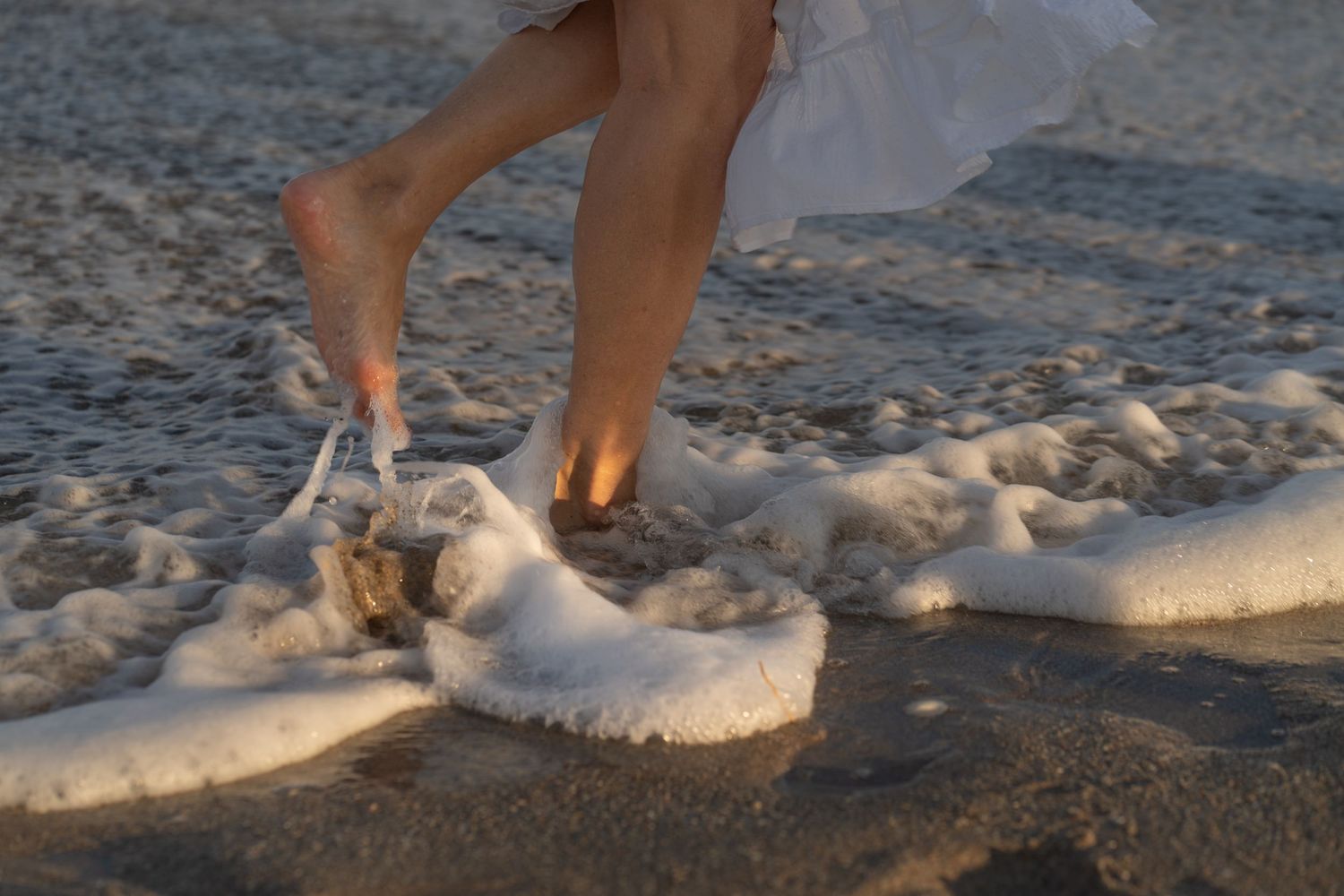 Barefoot walk in the surf at West Palm Beach, FL – waves washing over sandals on the shore at golden hour.