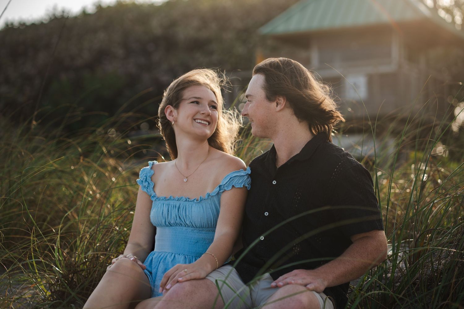 Miami engagement session of couple smiling at each other near beach dunes Red Reef Park