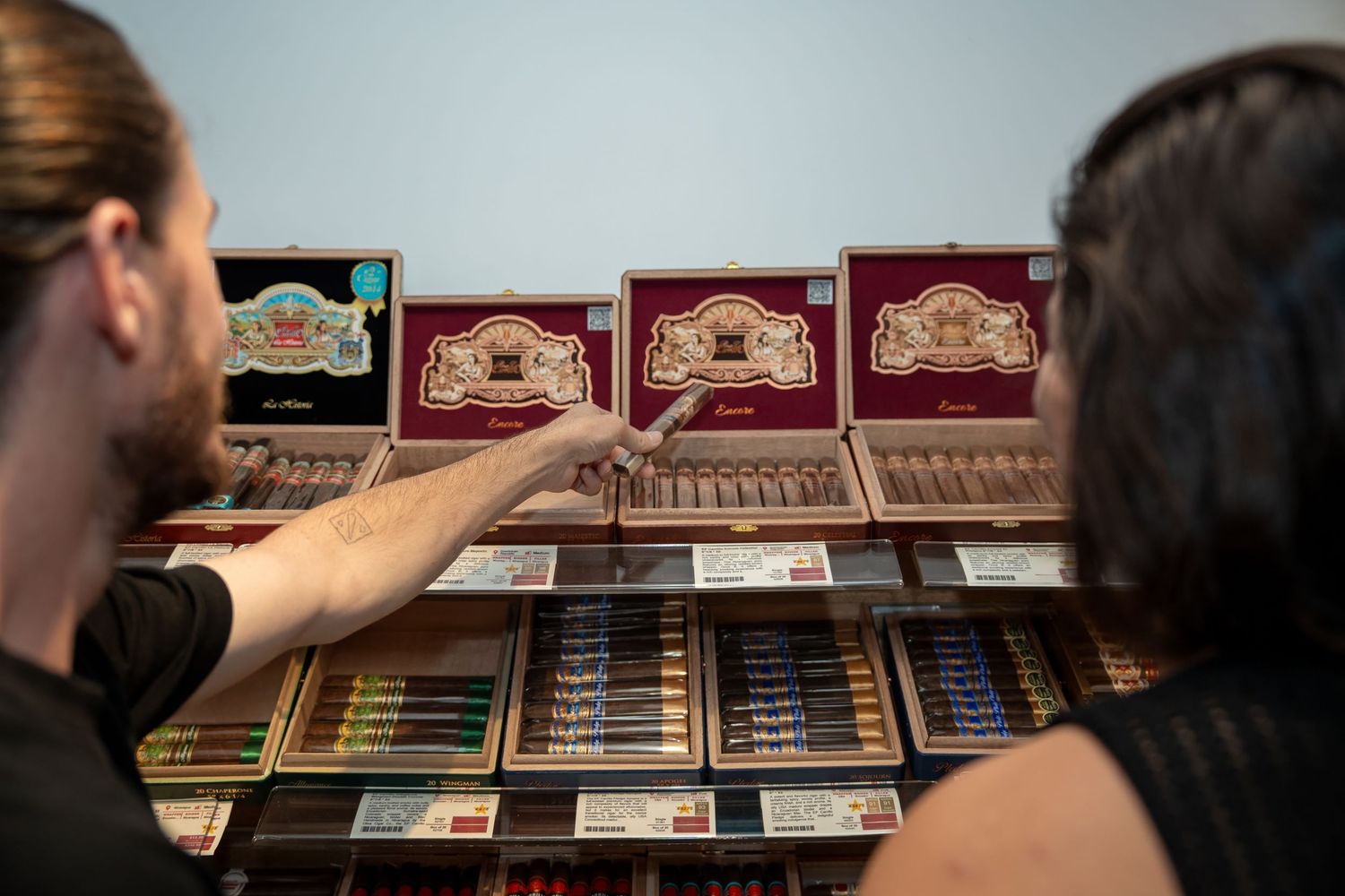 Guests browsing a cigar display inside Bartolo’s Wine Bar & Cigar Shop during the grand opening celebration.