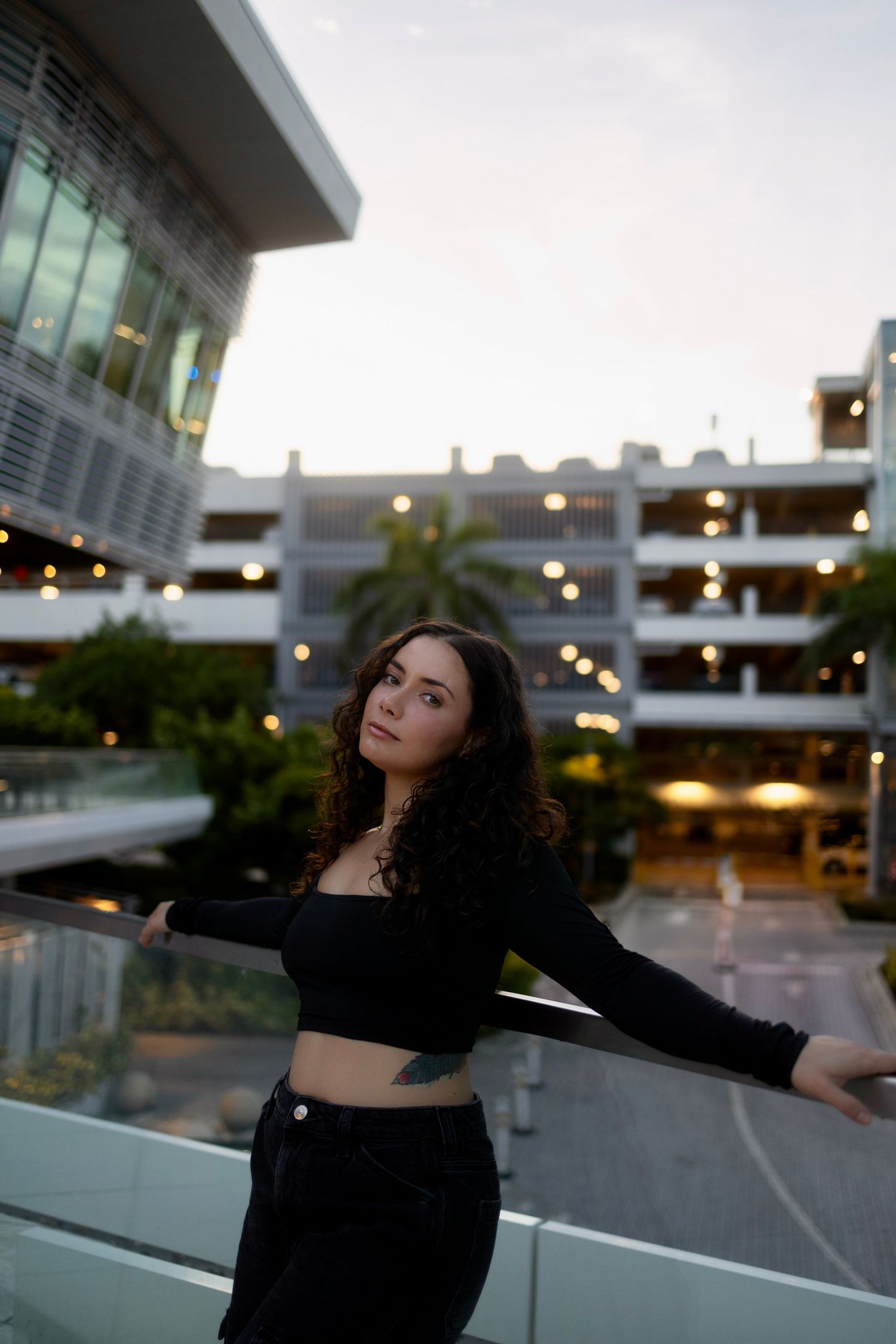 Woman posing near modern architecture during lifestyle portrait session in Aventura, Florida