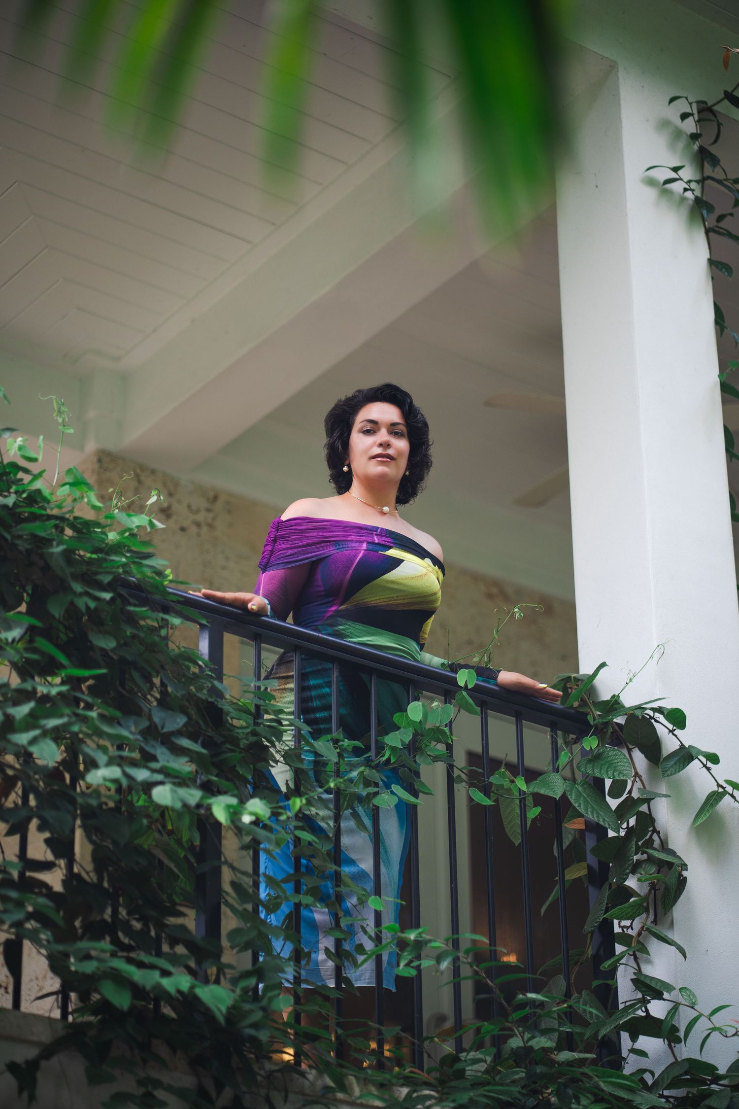 Editorial branding portrait of a woman on a balcony surrounded by greenery at Fairchild Tropical Botanic Garden.
