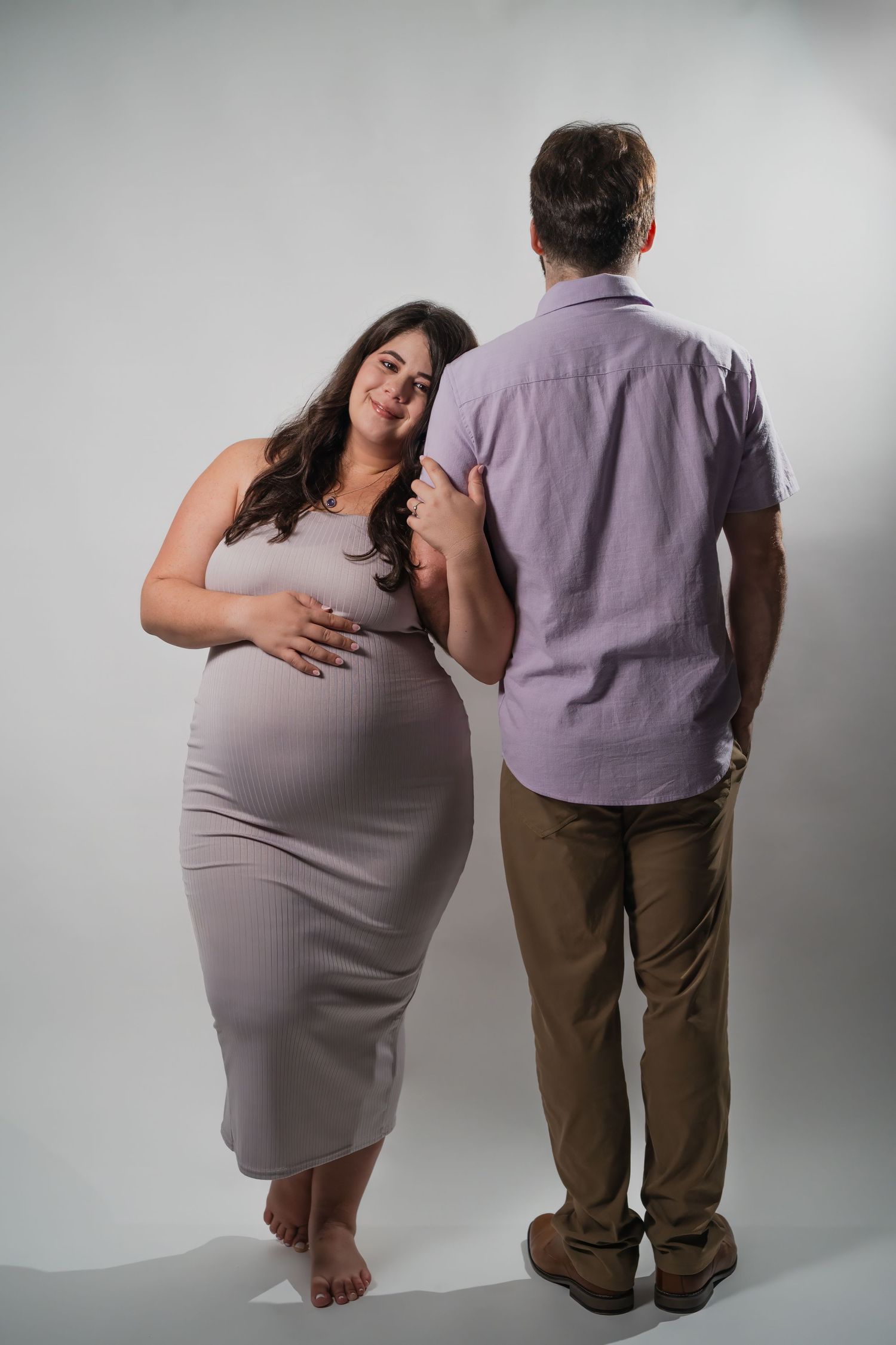 Studio maternity photo of expectant couple standing together in Fort Lauderdale with soft backdrop