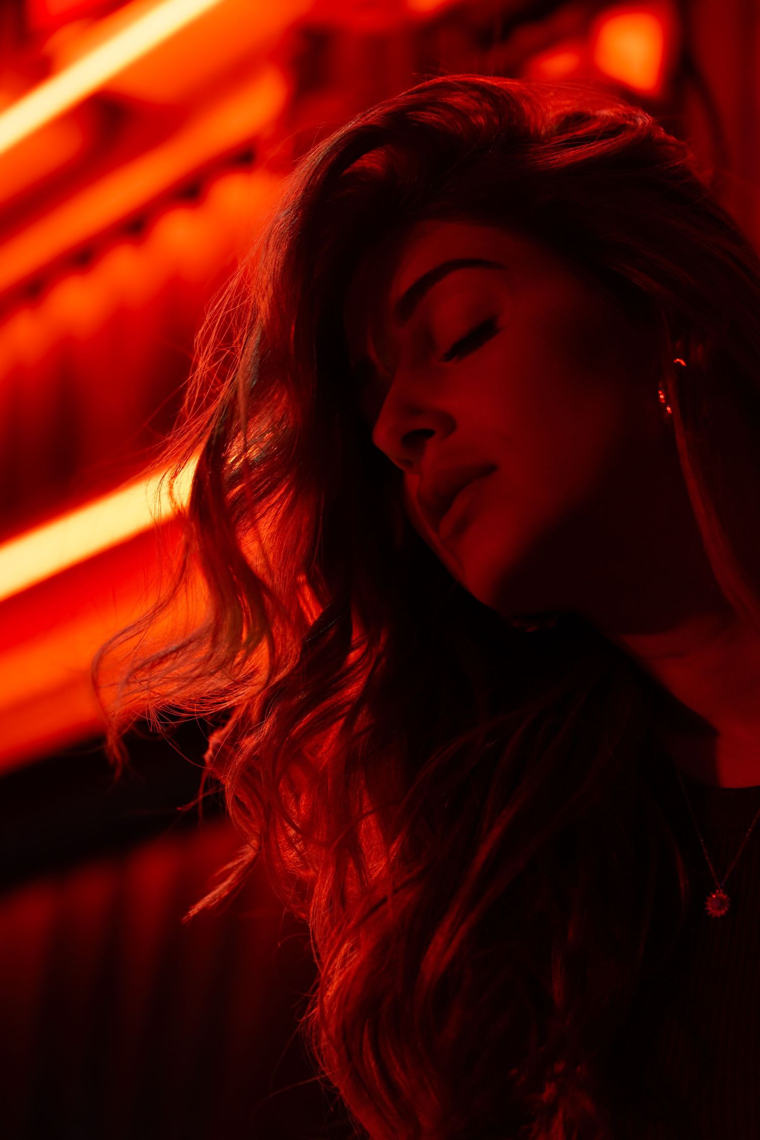 Cinematic red-lit portrait of model in studio, captured in Miami by local photographer.