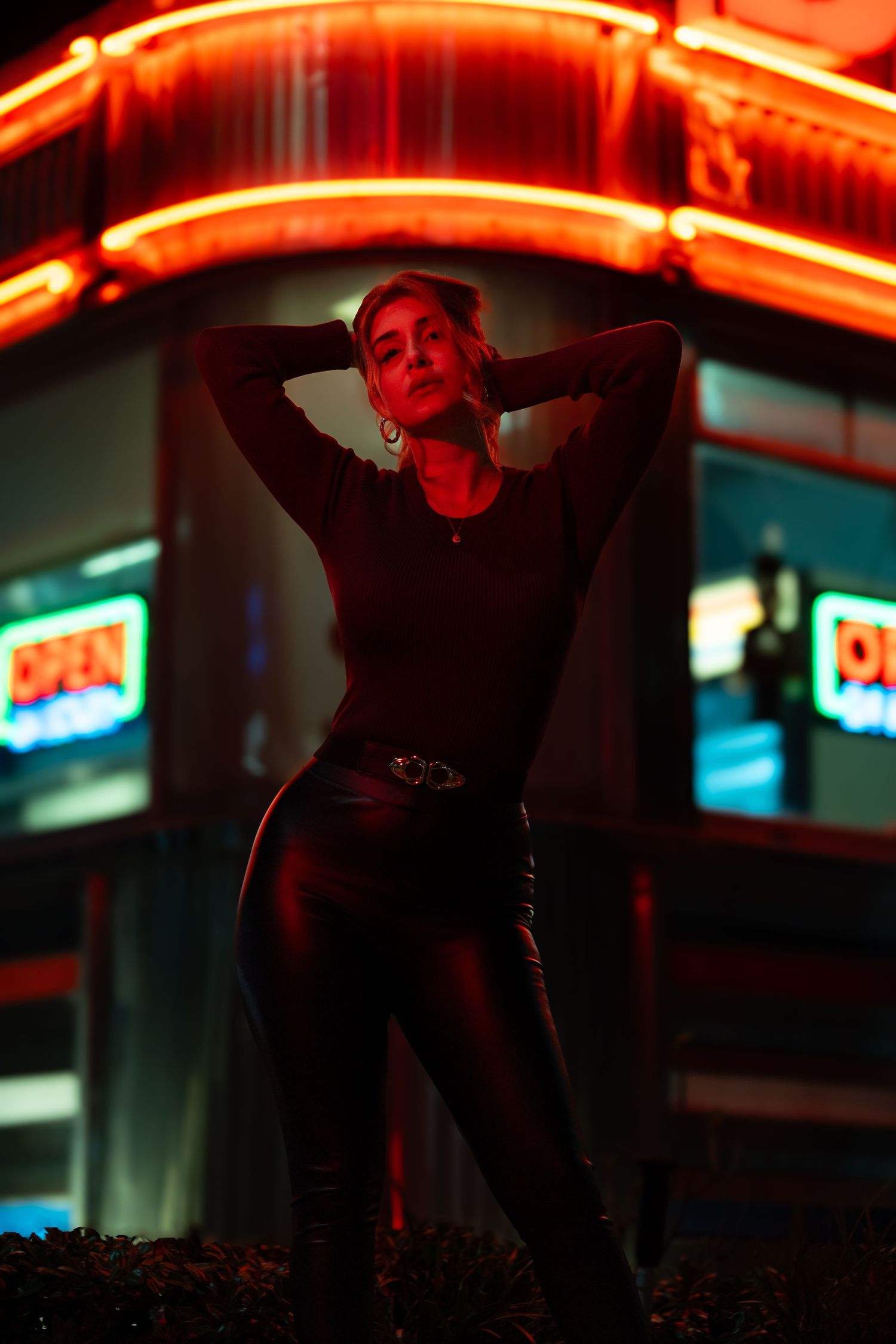 Night portrait of model under red neon sign with moody urban styling in South Florida.