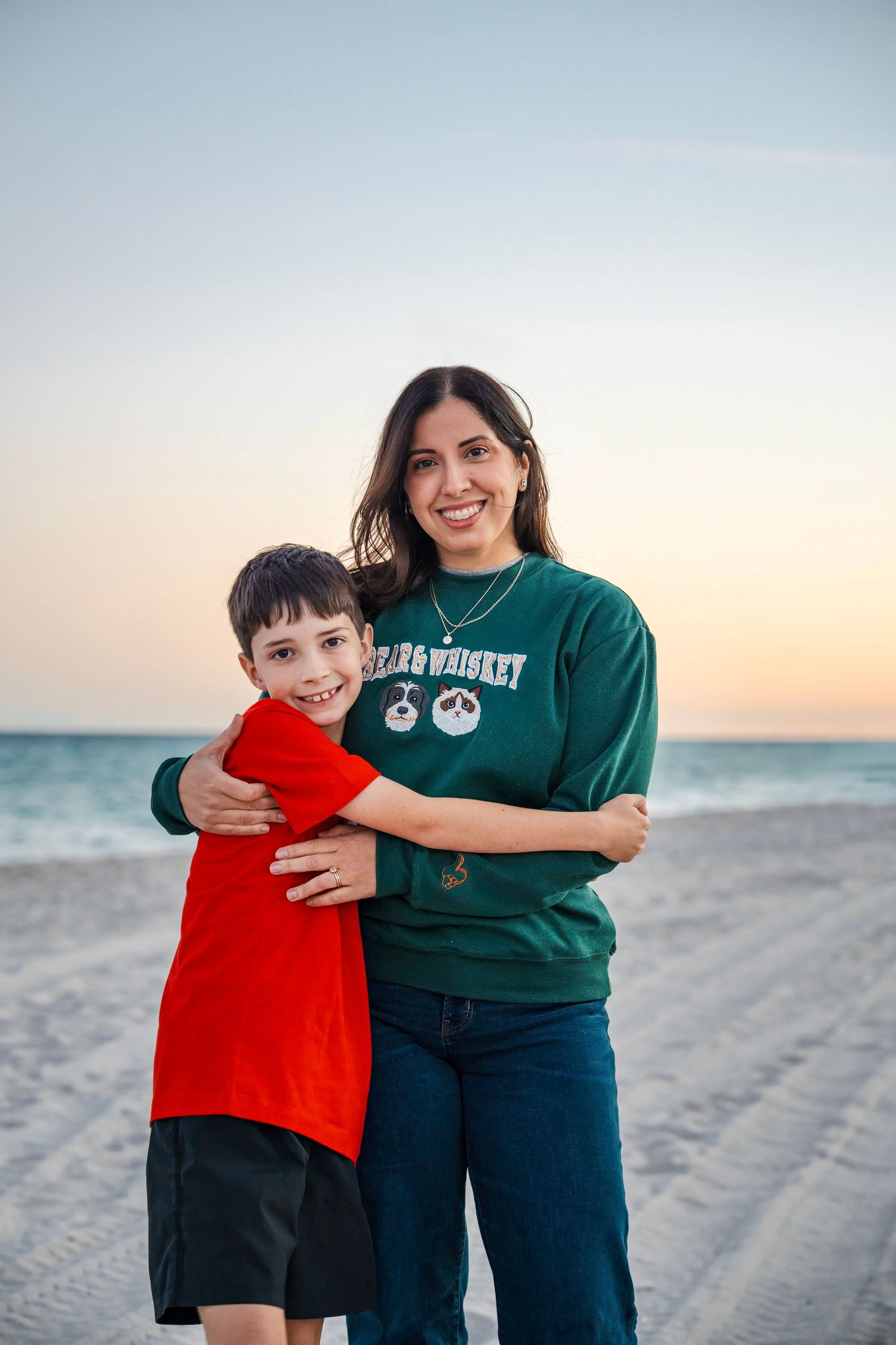 Beach family portrait of a mother and child standing together at sunset in South Florida.