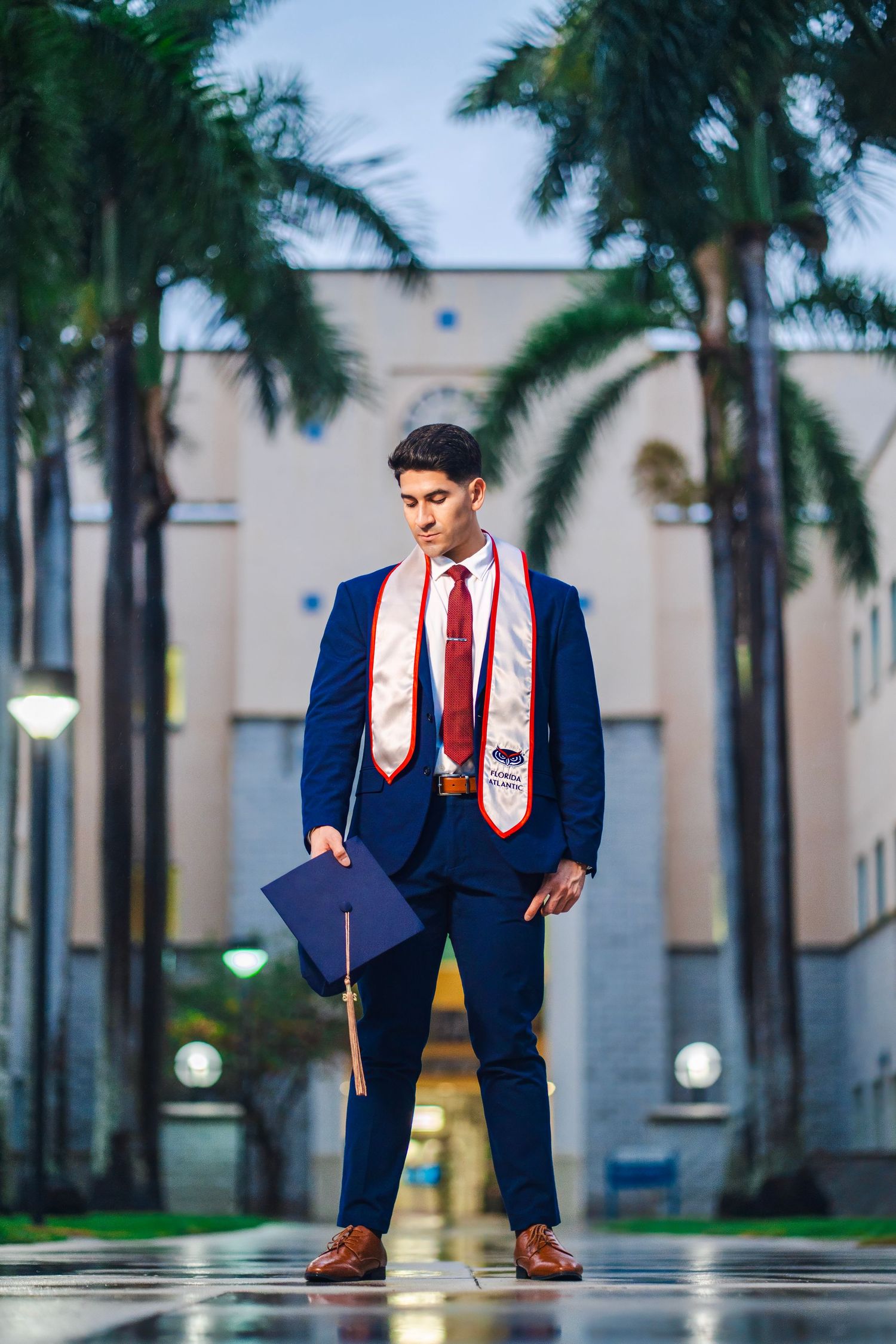 FAU graduation photos in Boca Raton by South Florida photographer, male graduate in cap and gown with palm trees