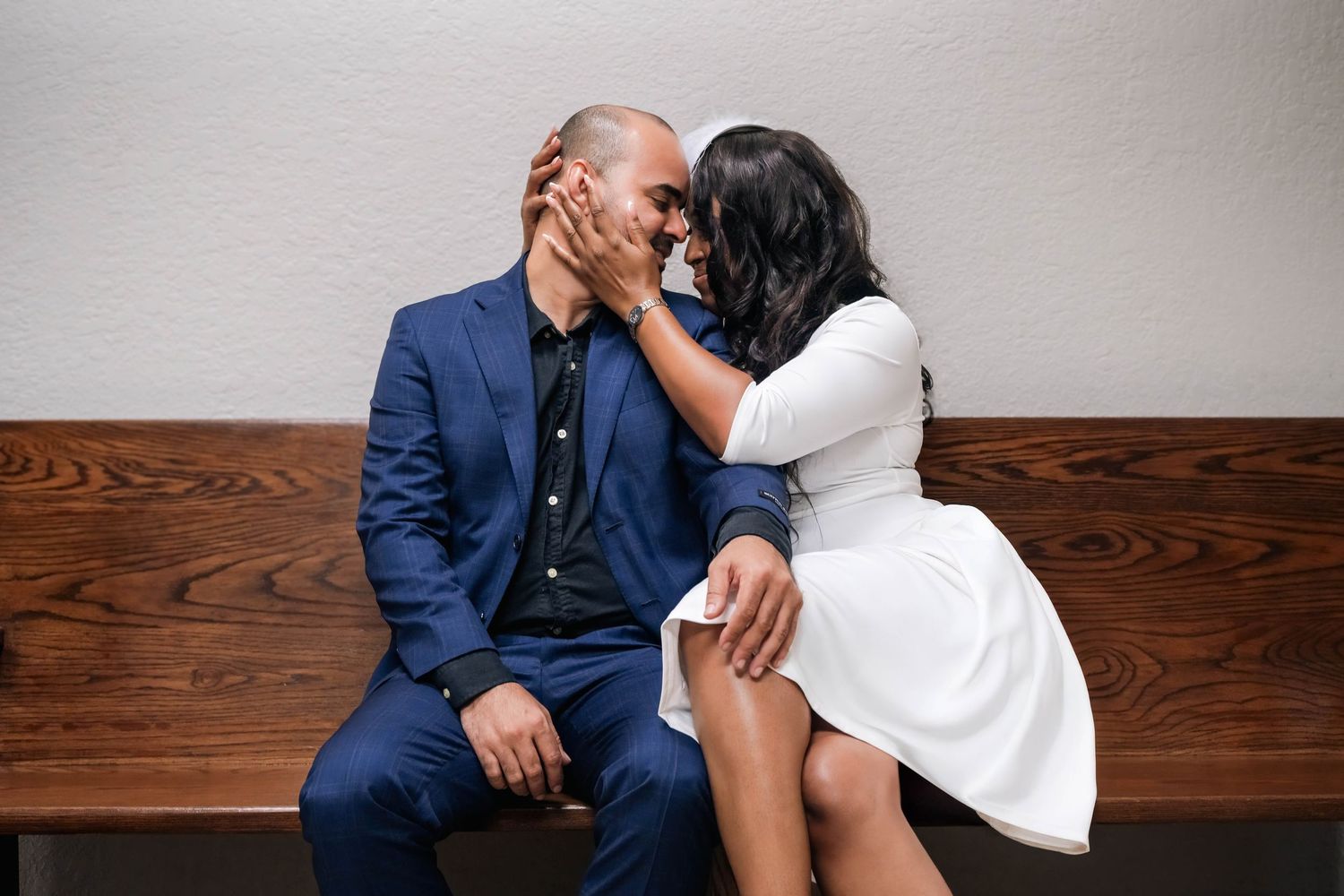 Intimate courthouse wedding portrait of a newly married couple sharing a quiet moment on a wooden bench, captured with a documentary-editori