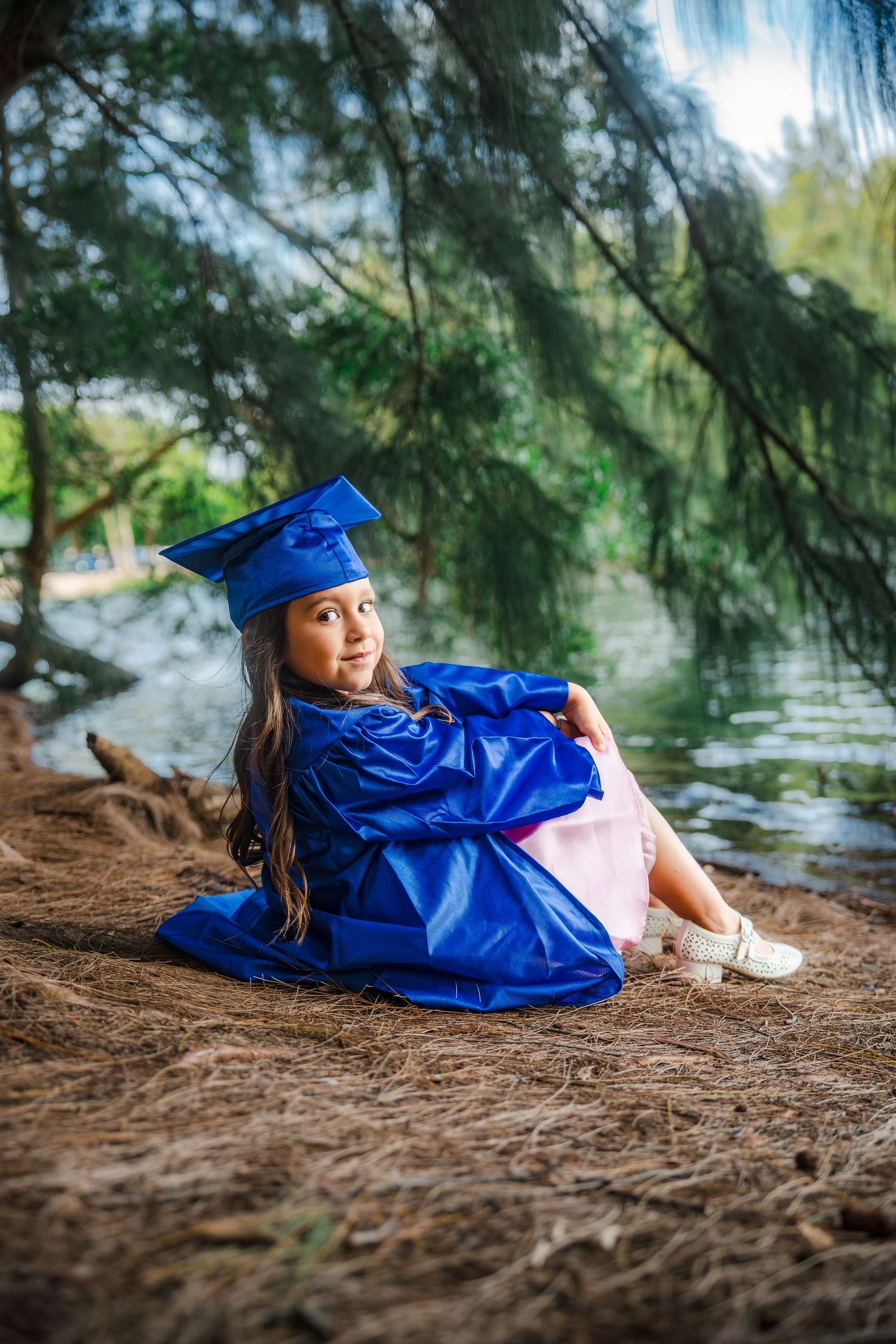 Kindergarten graduation portraits at Tree Tops Park in Davie by South Florida photographer, young girl in blue cap and gown