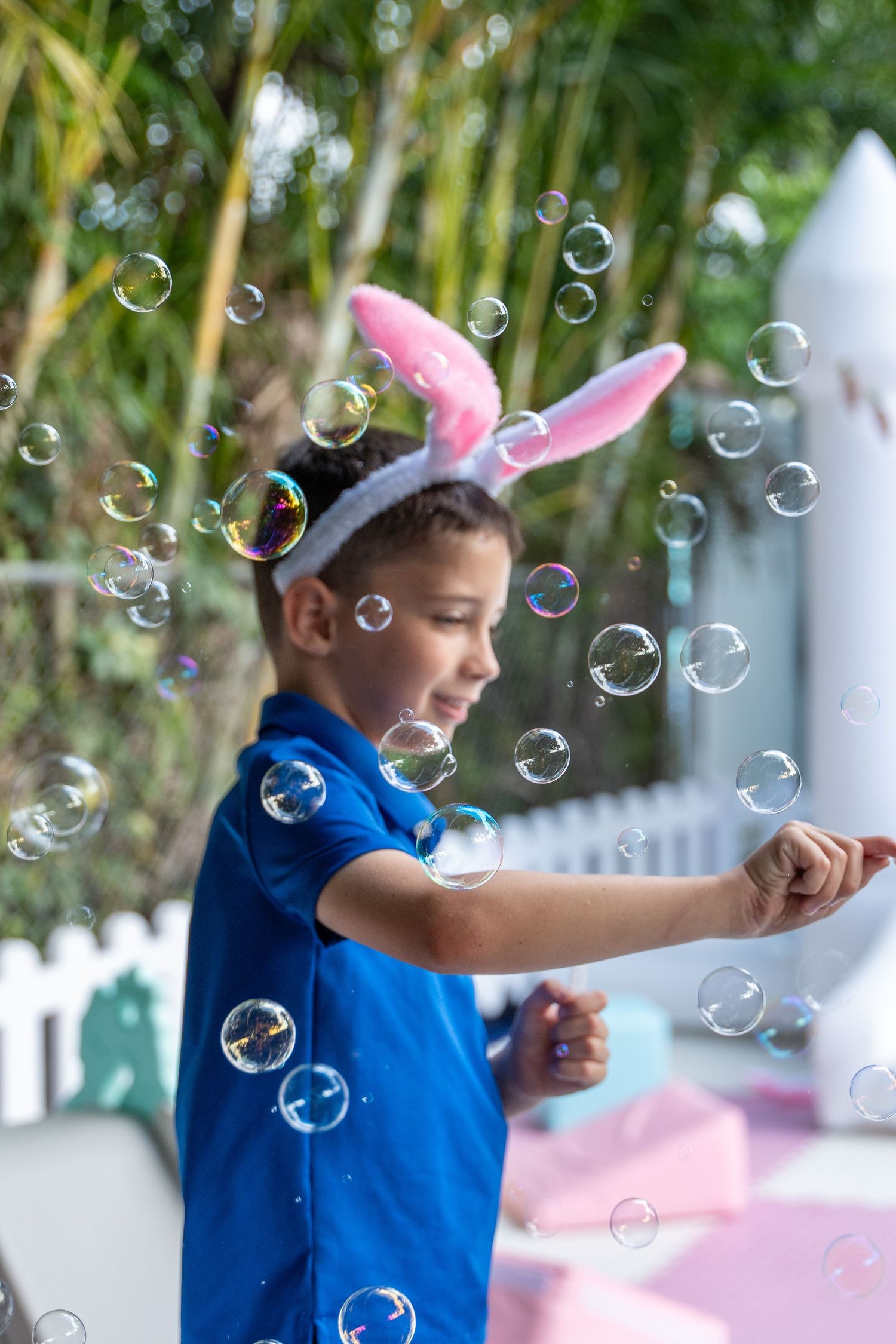 Candid birthday moment of a child playing with bubbles at an outdoor birthday party in South Florida.