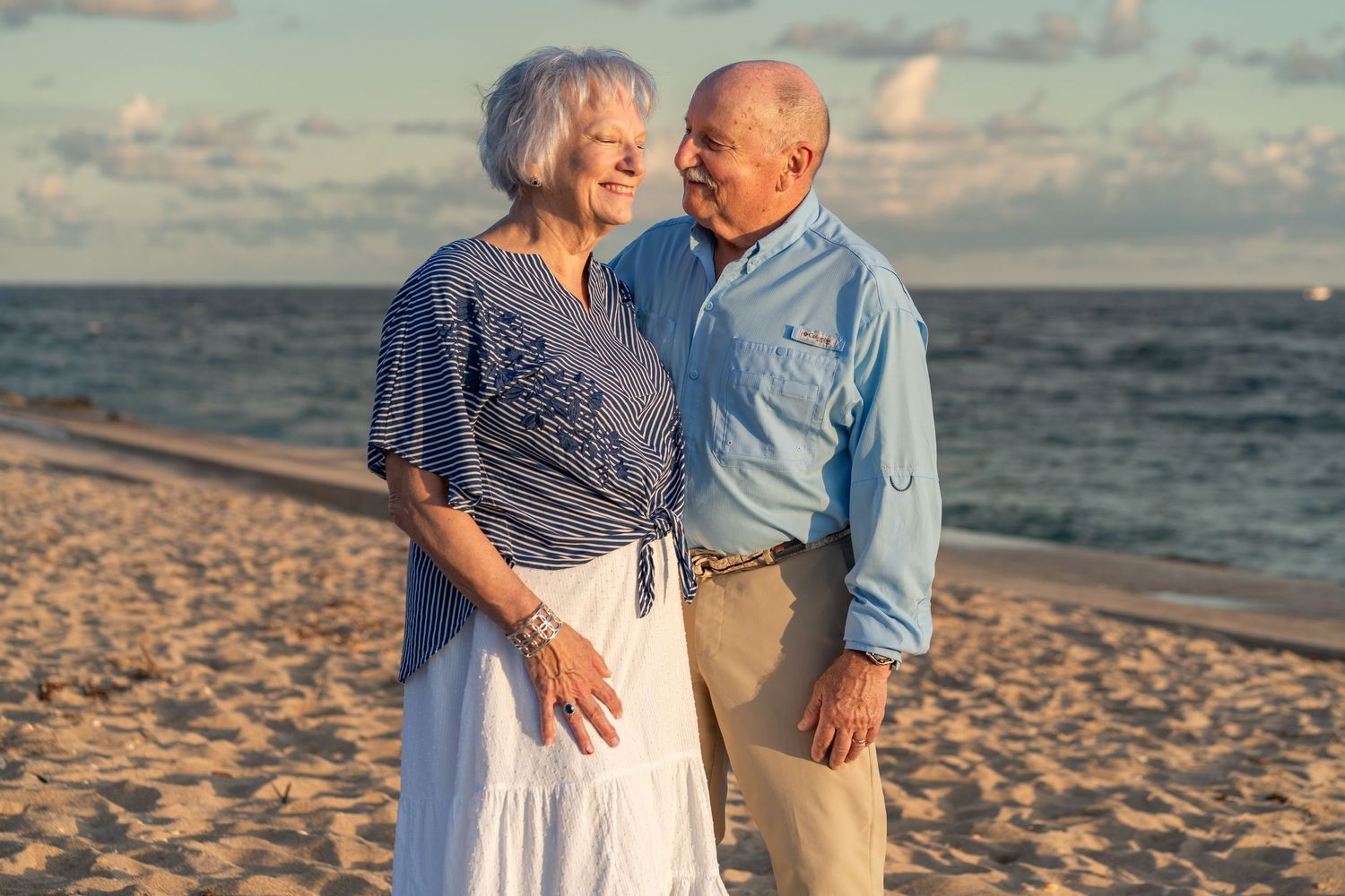 Elderly couple beach portrait in Palm Beach, FL – celebrating love and togetherness by the water under a golden sunset.