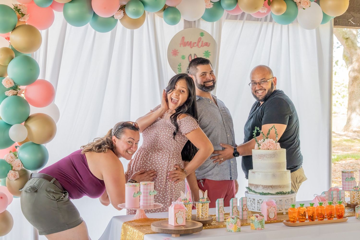Group photo of friends and family gathered around a dessert table at a South Florida baby shower celebration.