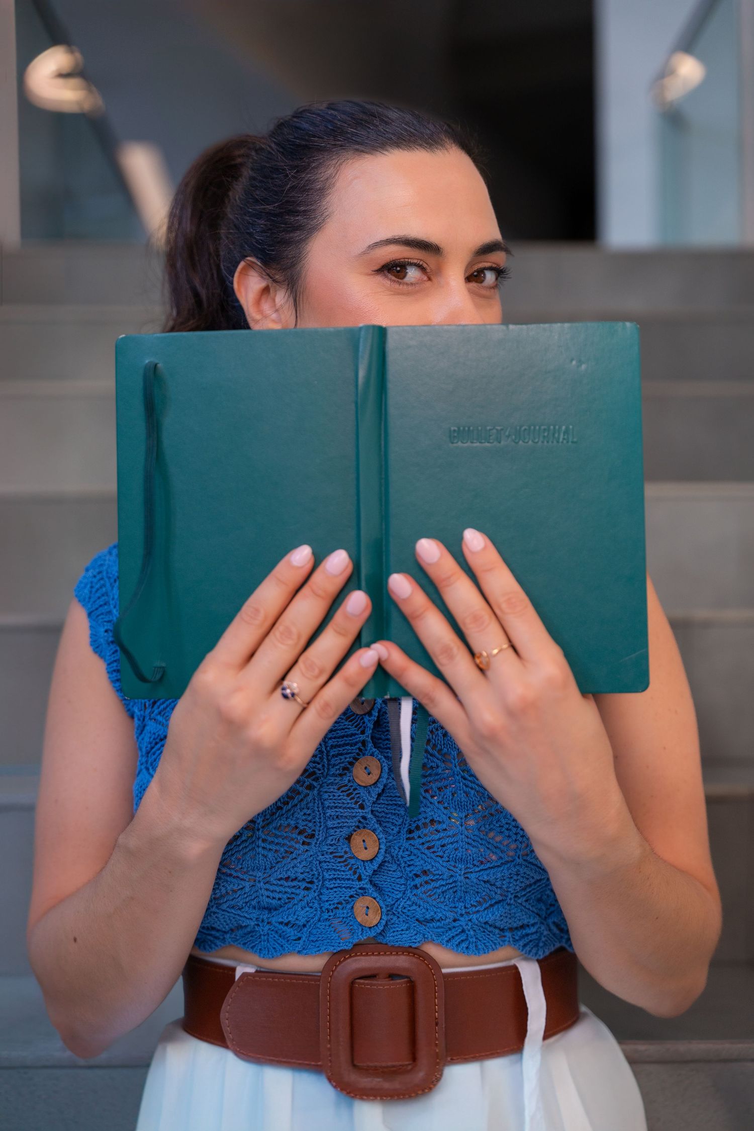 Creative entrepreneur branding portrait in Fort Lauderdale, FL – playful moment hiding behind a planner.