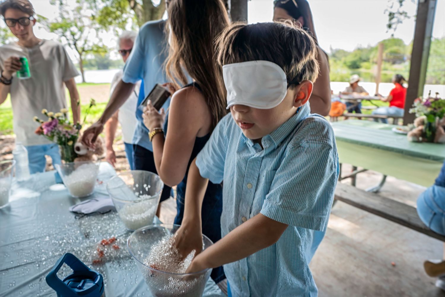 Guests participating in a baby shower game while blindfolded at a South Florida outdoor celebration.