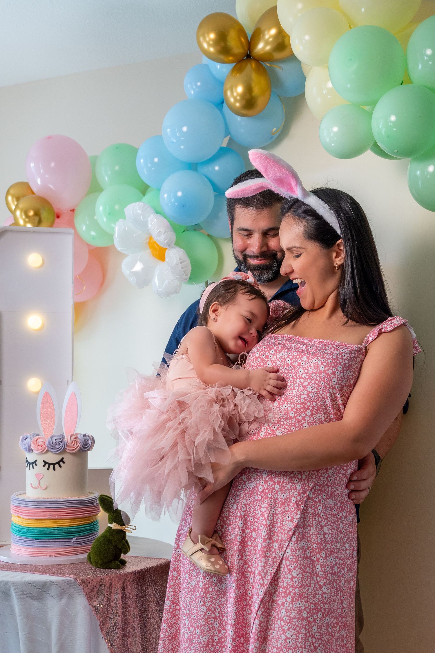 Birthday portrait session in South Florida by photographer, mother holding child with pastel balloons and soft studio styling