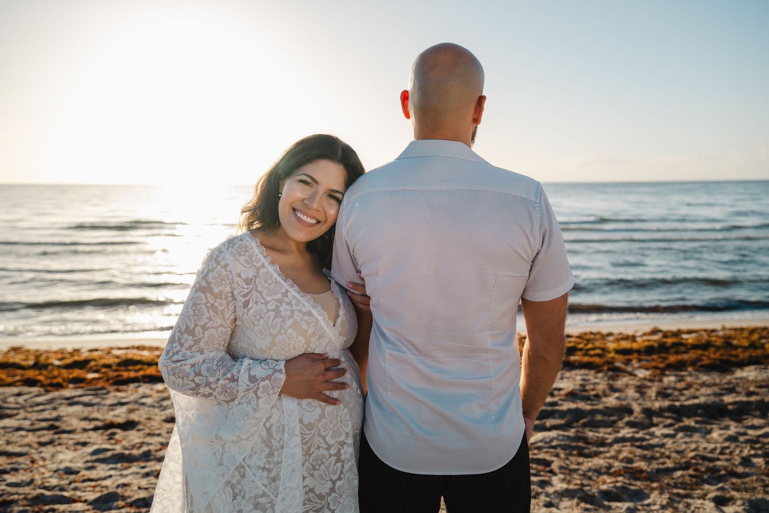 Maternity portrait of woman in lace dress with ocean view at Dania Beach