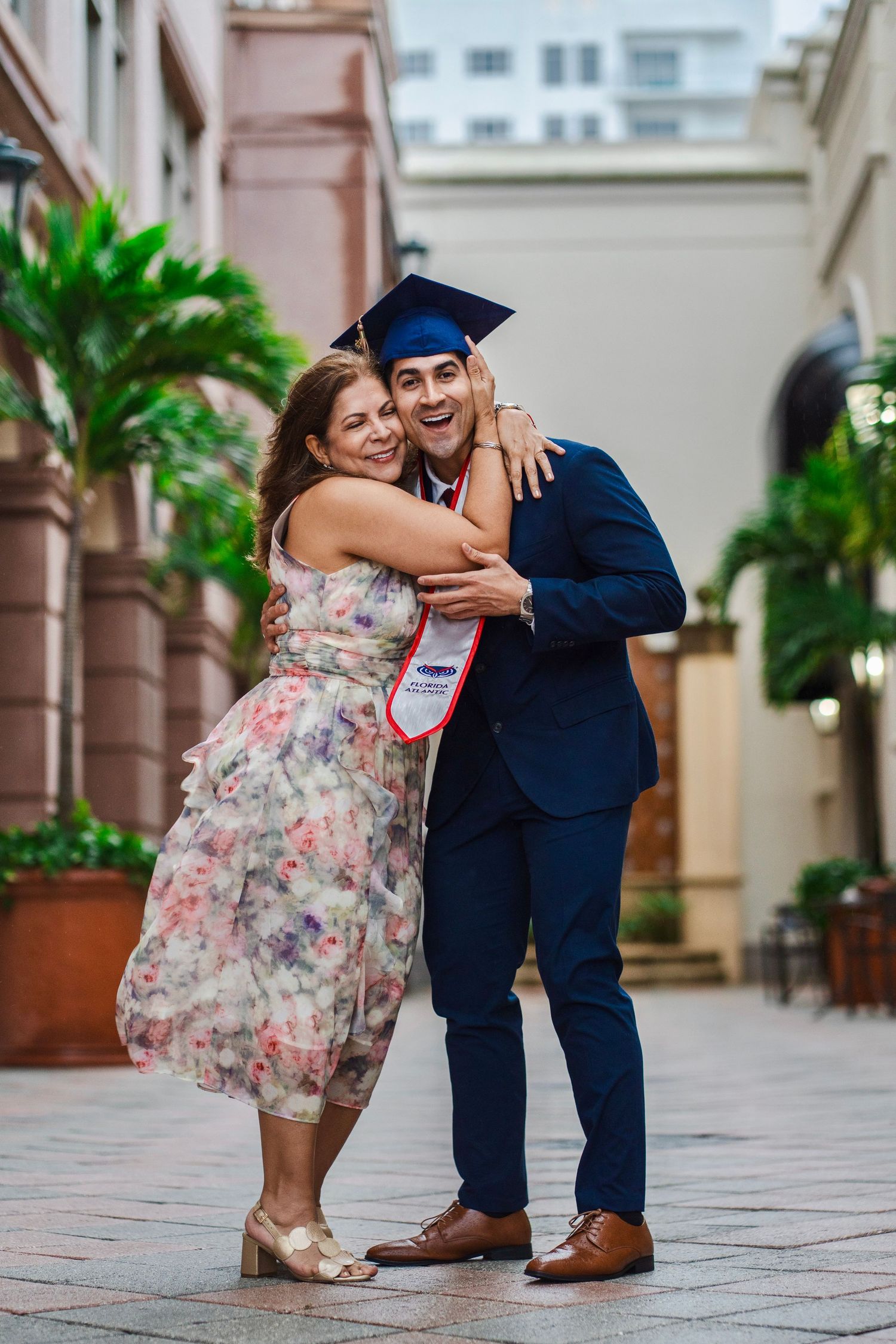FAU graduation photos in Boca Raton by South Florida photographer, graduate celebrating with partner in courtyard