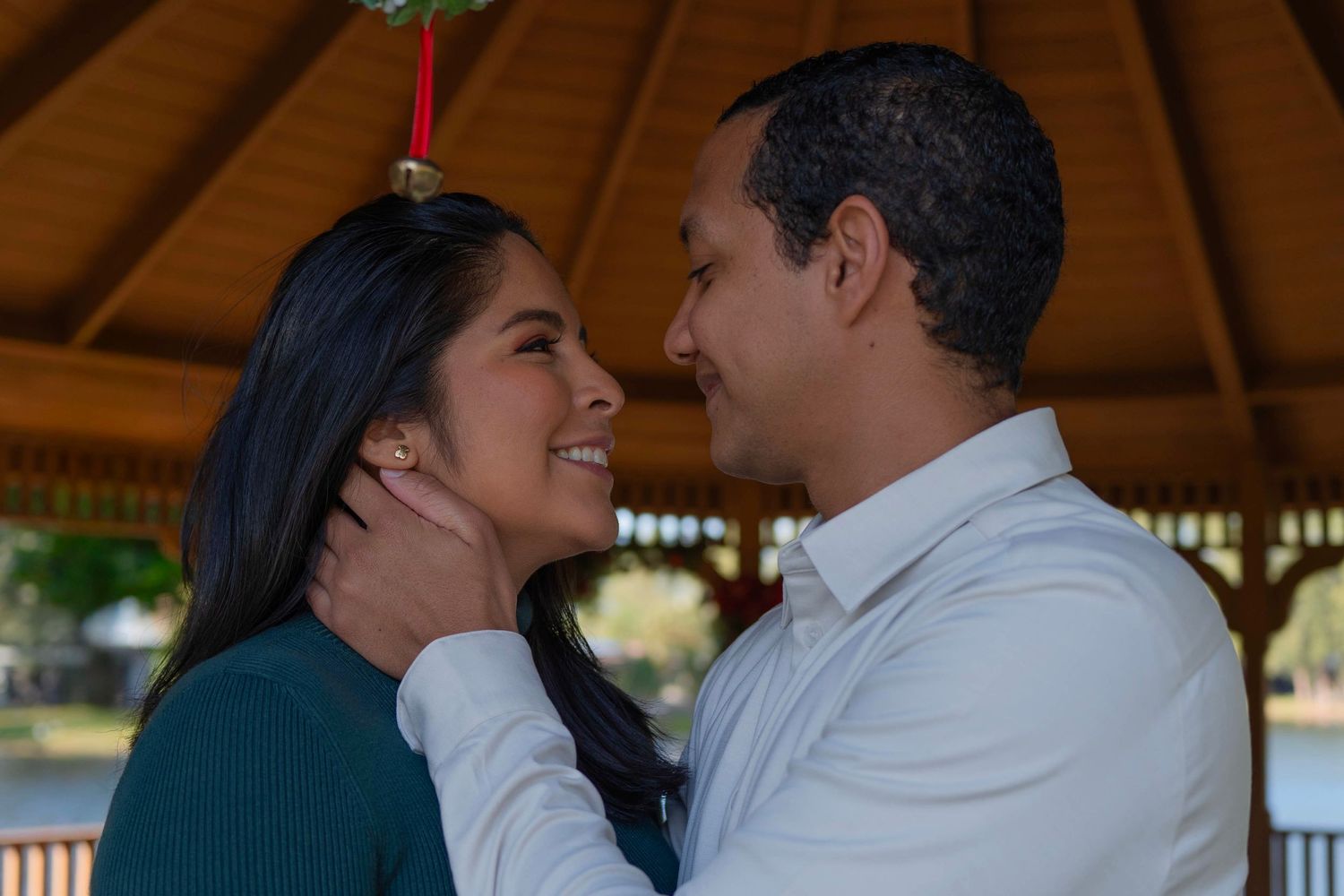 Romantic holiday couple session in Fort Lauderdale, FL – sweet moment under mistletoe with warm holiday lights.