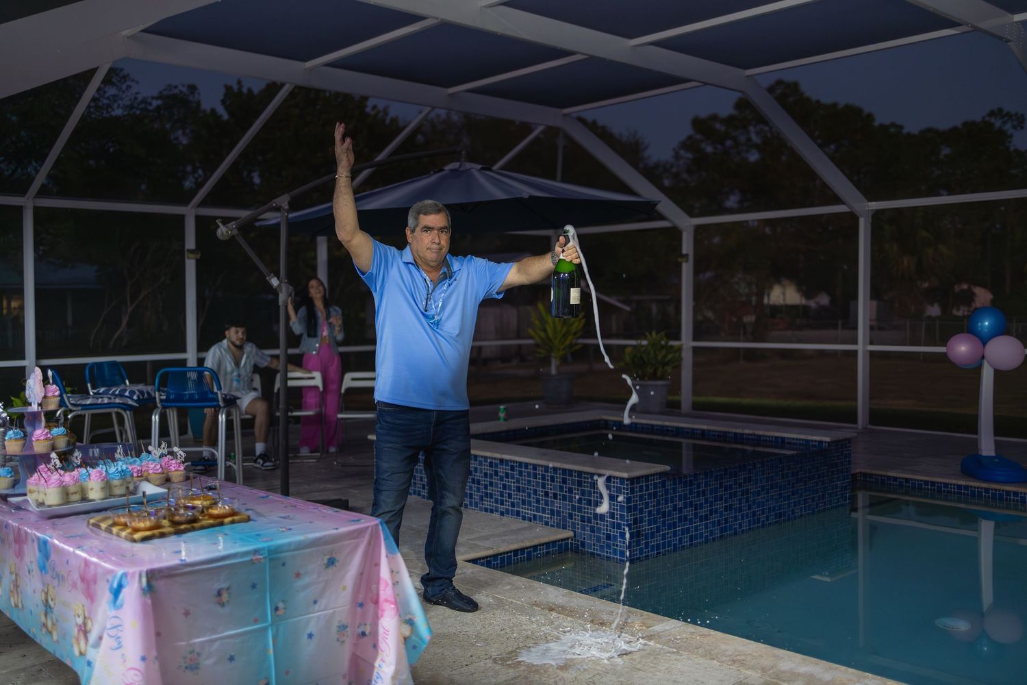 Father celebrating a gender reveal announcement by the pool, captured during an intimate backyard event in South Florida.