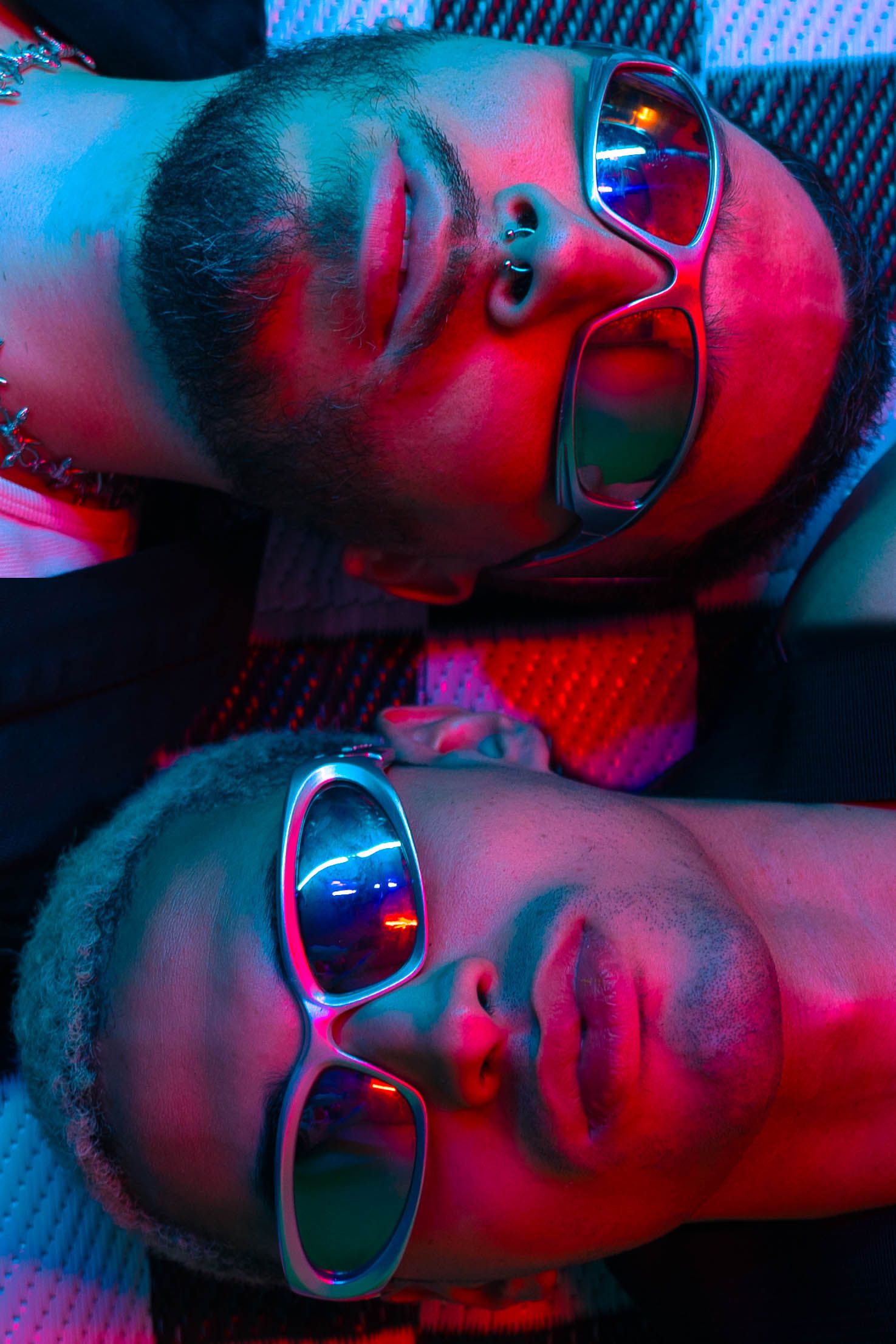 Neon duo portrait in Boca Raton, FL – two stylish men in sunglasses posing under moody blue and red lights.