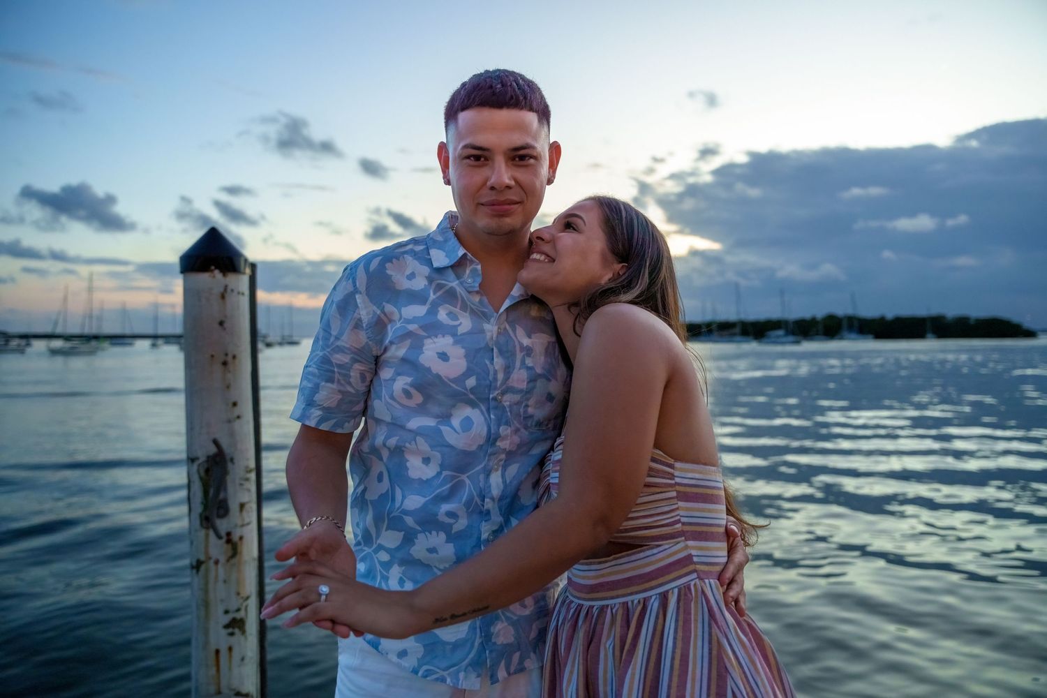 Joyful engagement session at sunset in Key Biscayne, FL, capturing a couple’s embrace by the serene waterfront.