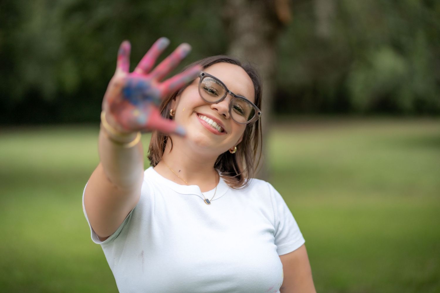 Smiling mom holding up a paint-covered hand during a candid lifestyle shoot in Pembroke Pines.