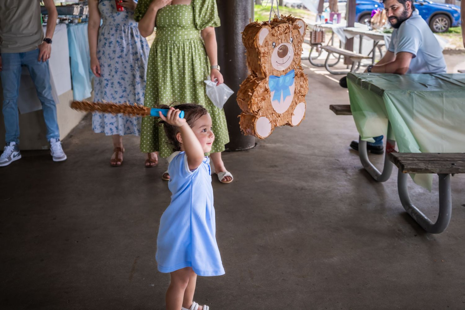 Toddler playing with a teddy bear decoration during a baby shower celebration in South Florida.