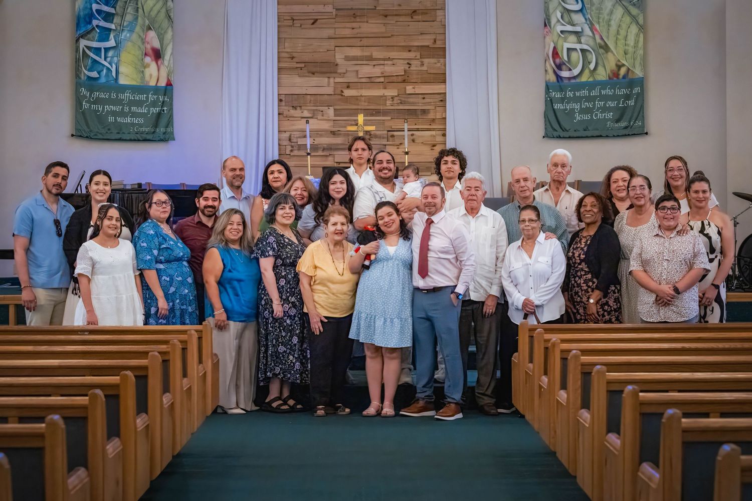 Large family group portrait inside a church following a baptism ceremony. Multigenerational