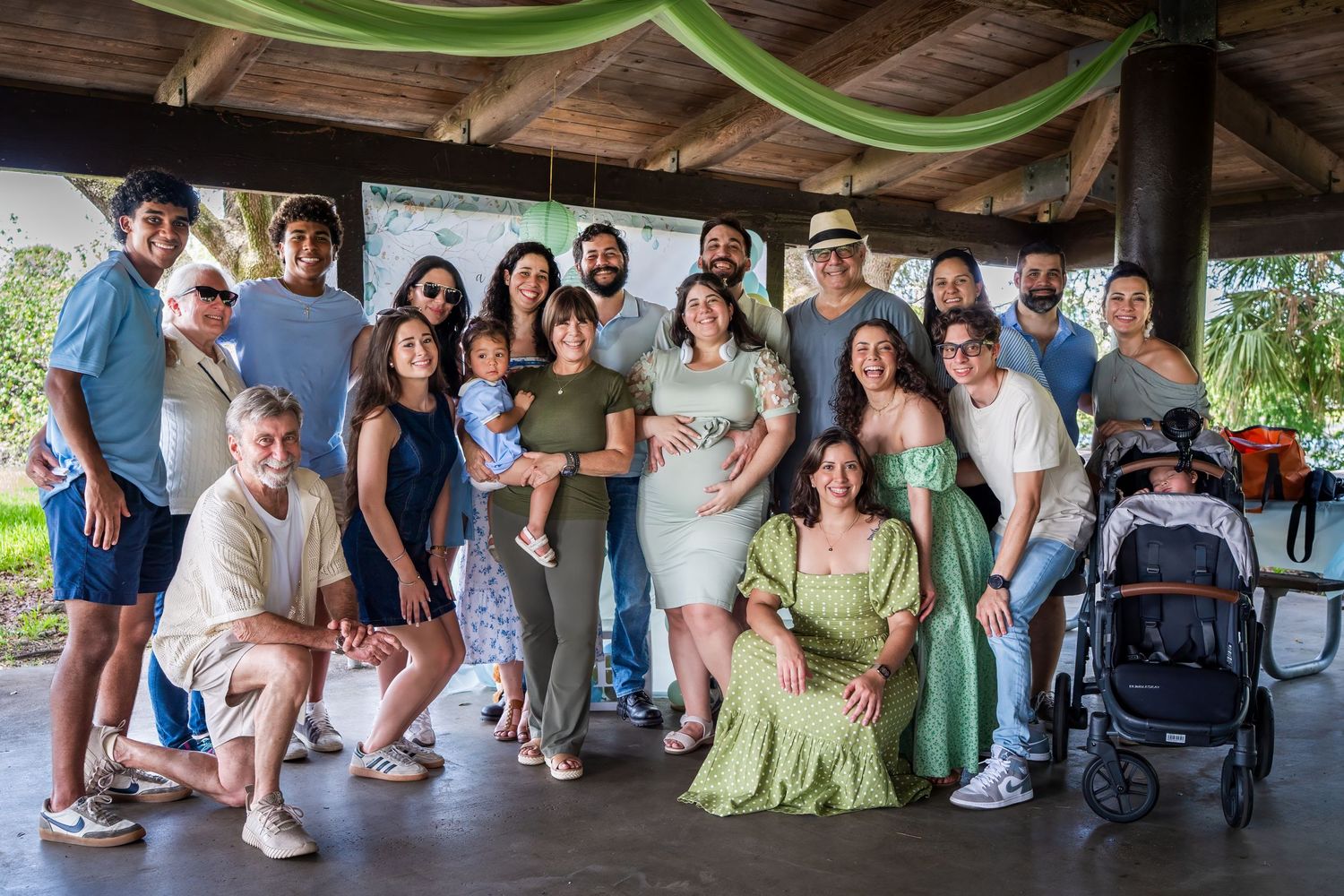 Large group photo of friends and family celebrating a baby shower together at an outdoor pavilion in South Florida.