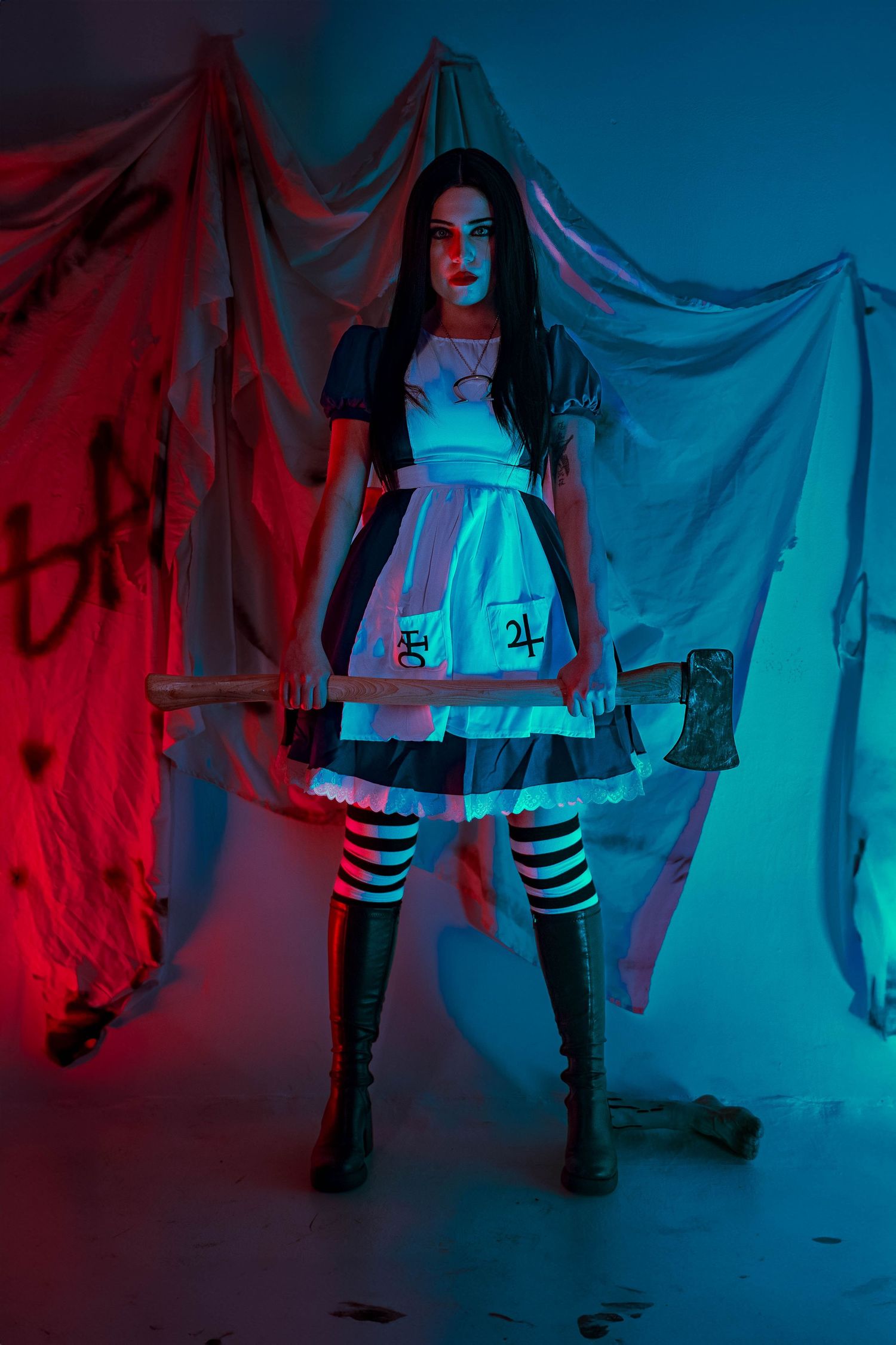 Horror-inspired Alice in Wonderland shoot in Fort Lauderdale, FL – eerie cosplay portrait with moody blue and red lighting.