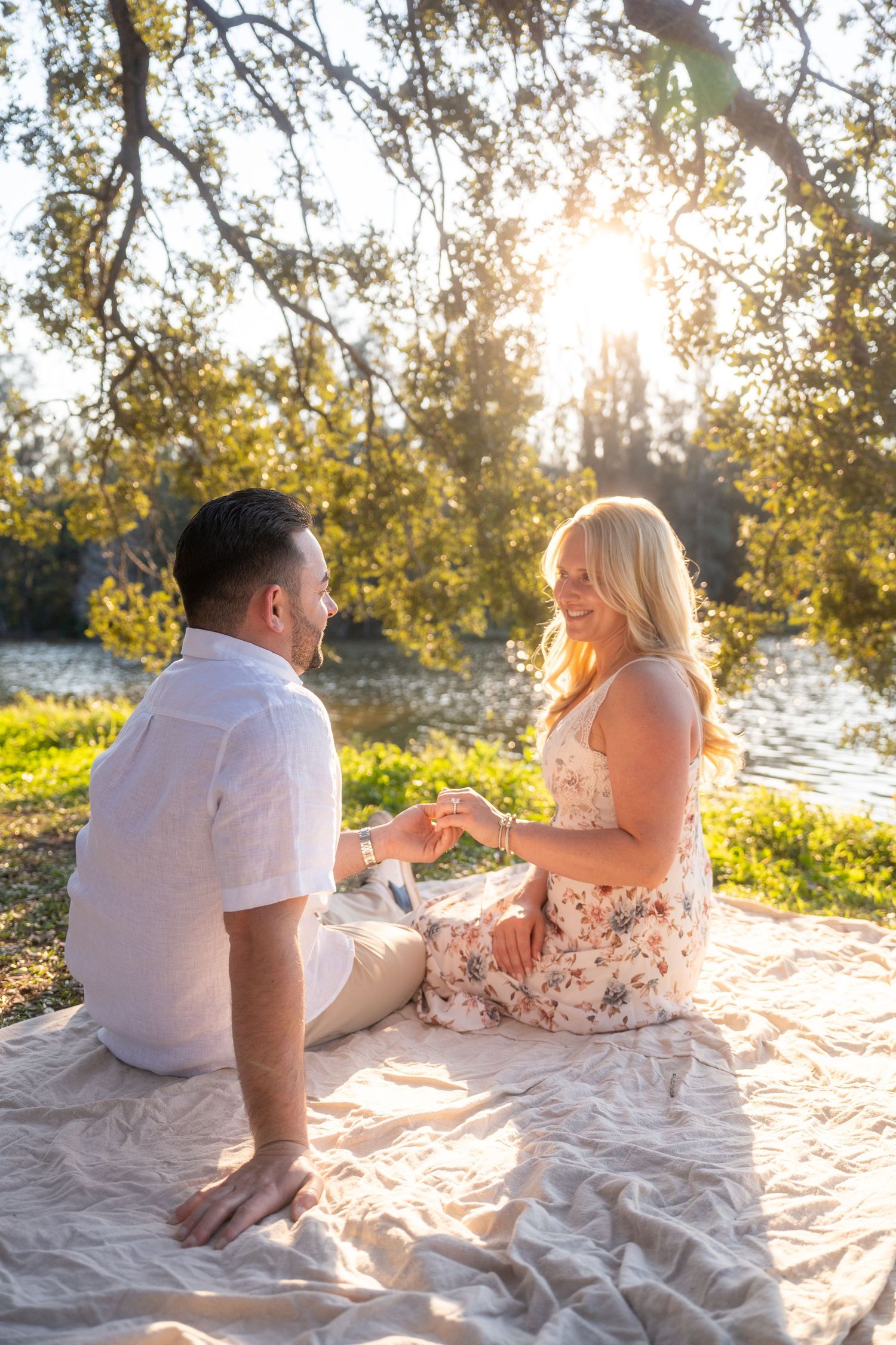 Natural engagement moment captured through a guided photography experience with couple sitting together during picnic