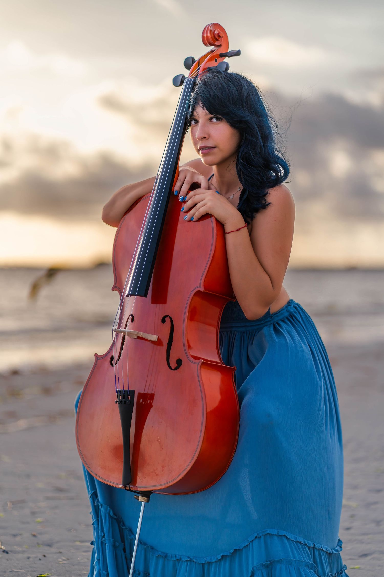 Cellist posing with cello on South Florida beach during creative branding session