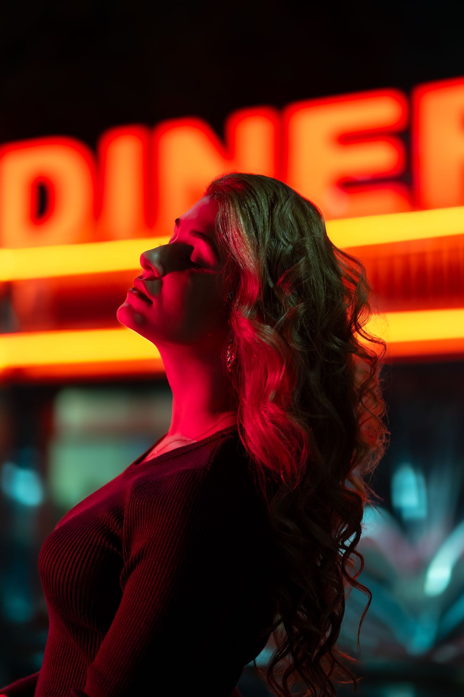 Dramatic nighttime portrait with red neon glow in Miami featuring Florida-based model.