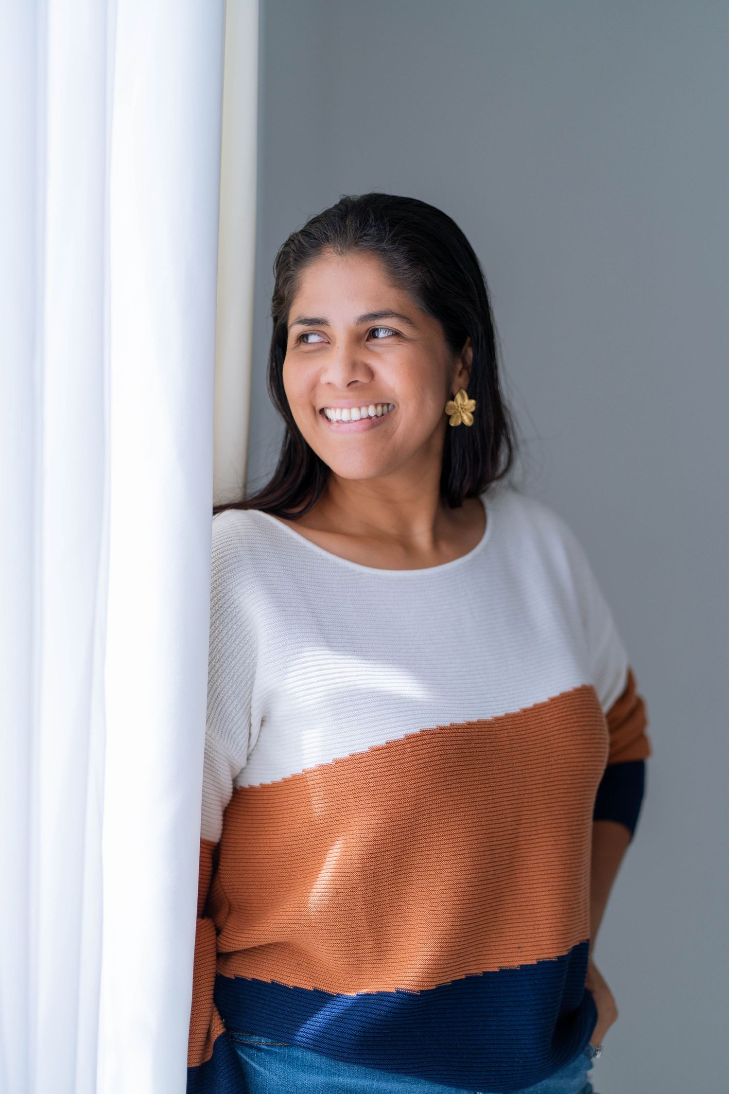 Natural light branding session in West Palm Beach, FL – female business owner posing by a window with soft lighting.