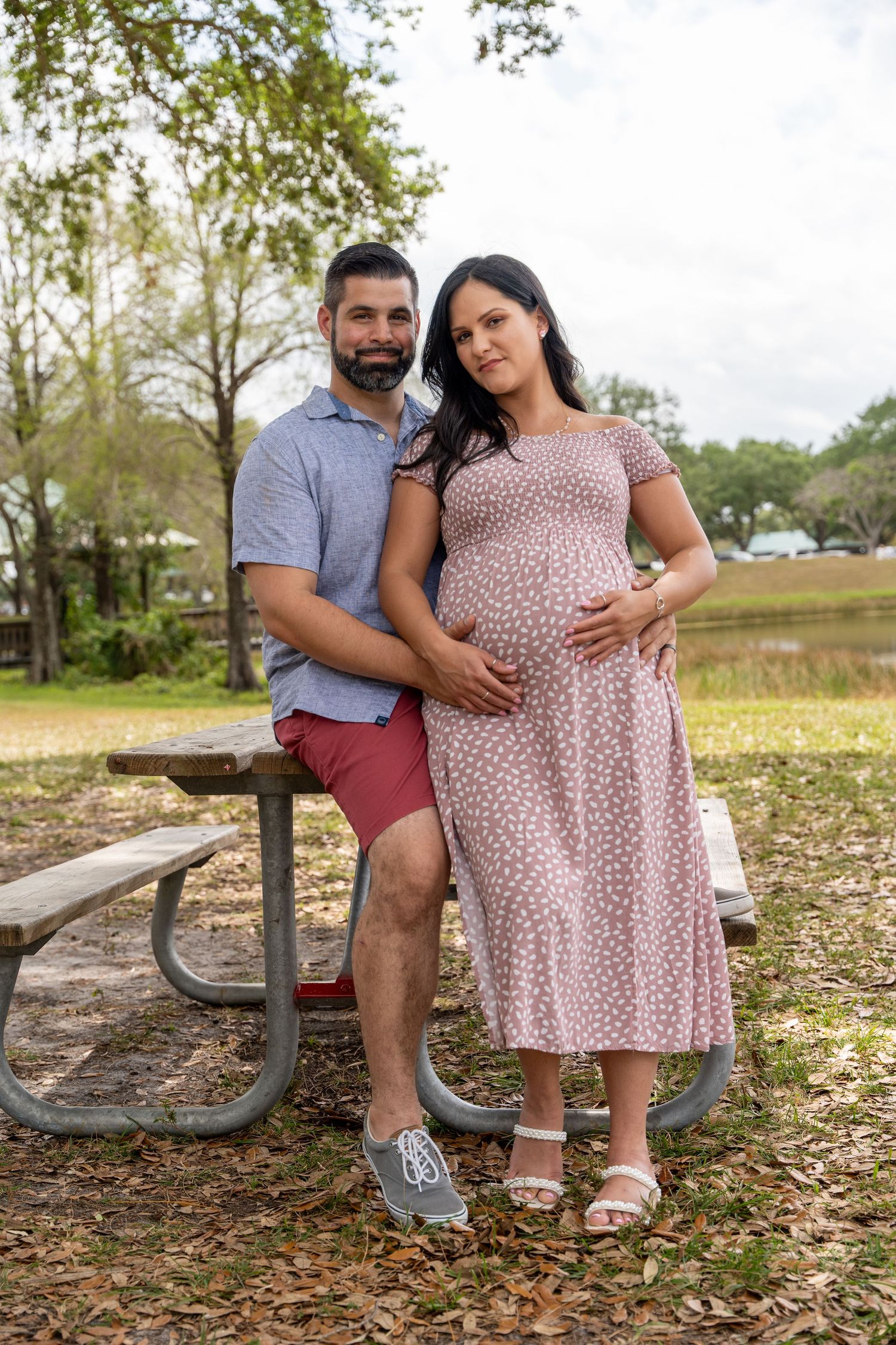 Expecting couple standing together outdoors during a casual South Florida maternity portrait session.