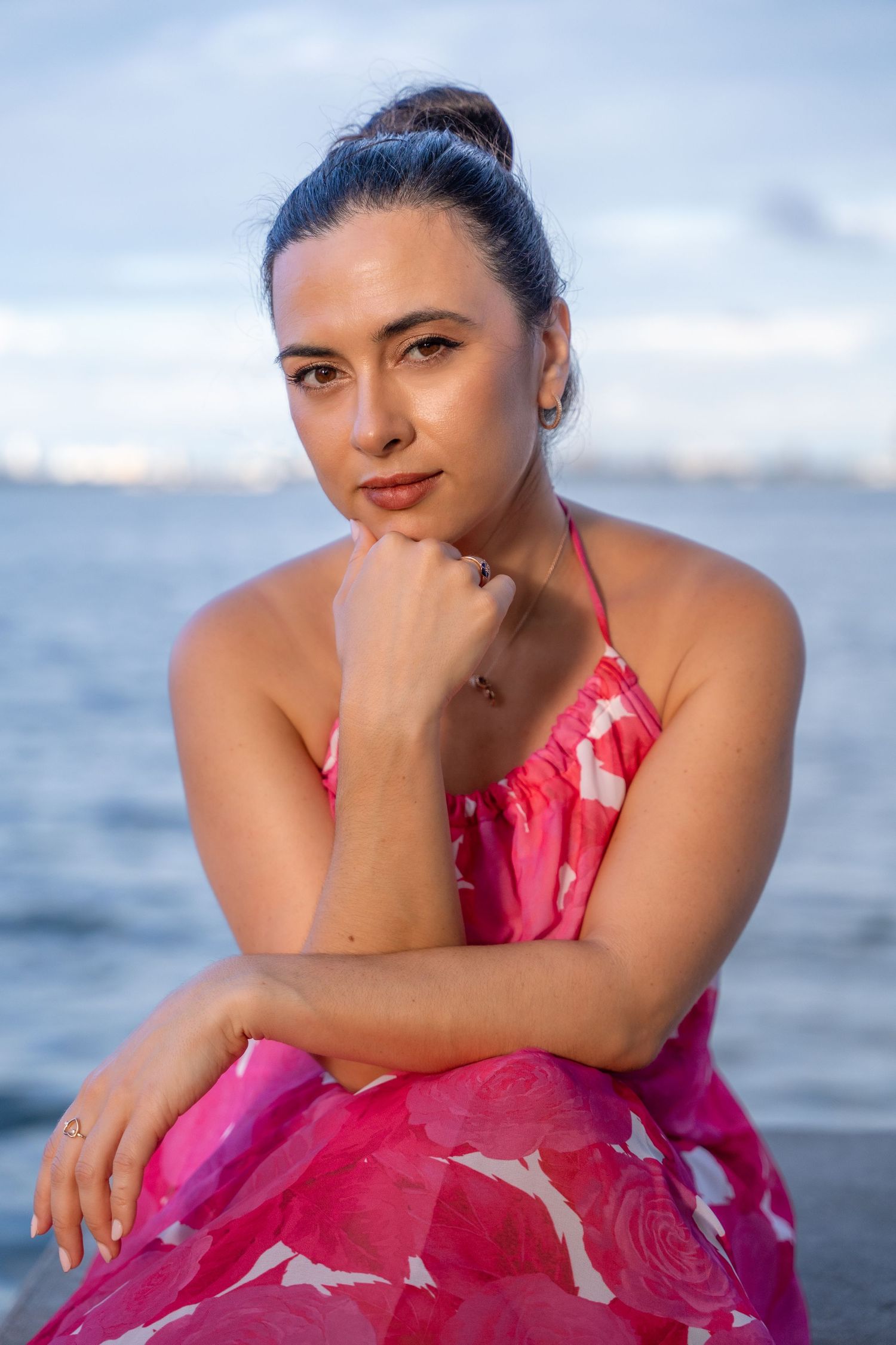 Golden hour beach session in West Palm Beach, FL – soft, natural light highlights a woman in a flowy pink dress.