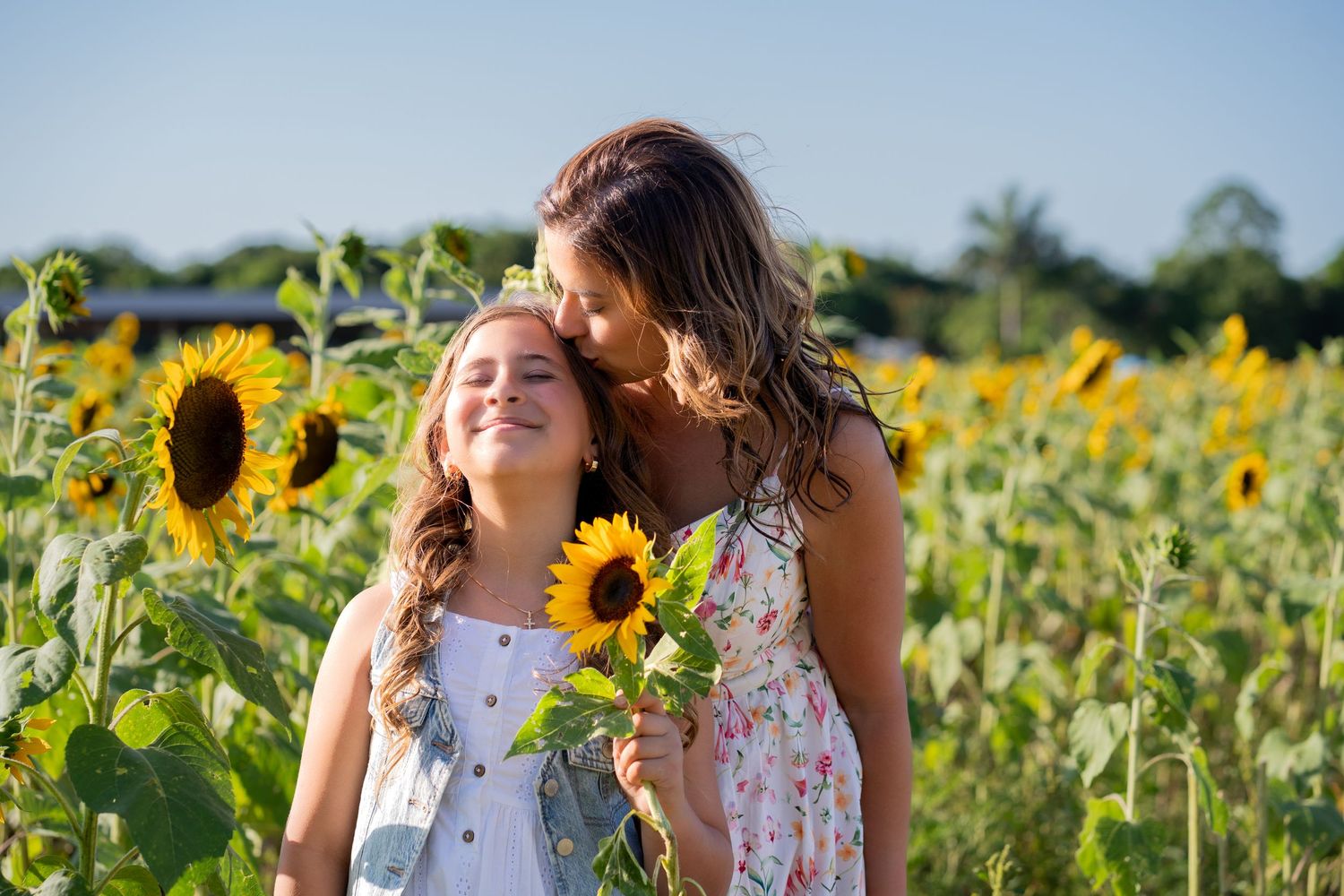 Mother-daughter birthday photo in sunflower field at Berry Farms.