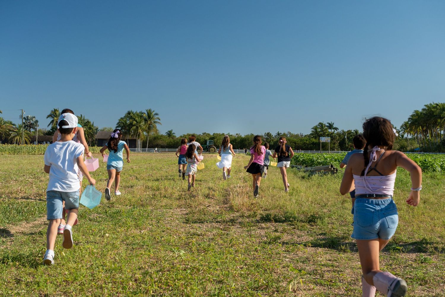 Kids running in open field at Berry Farms, playful birthday party photography in South Florida.