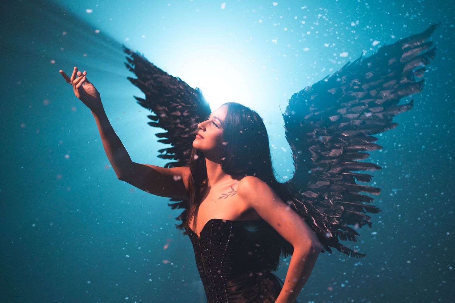 Fantasy-inspired celestial portrait at CFX Studio, Miami, FL – elegant model with black wings in a snowy dreamlike setting.