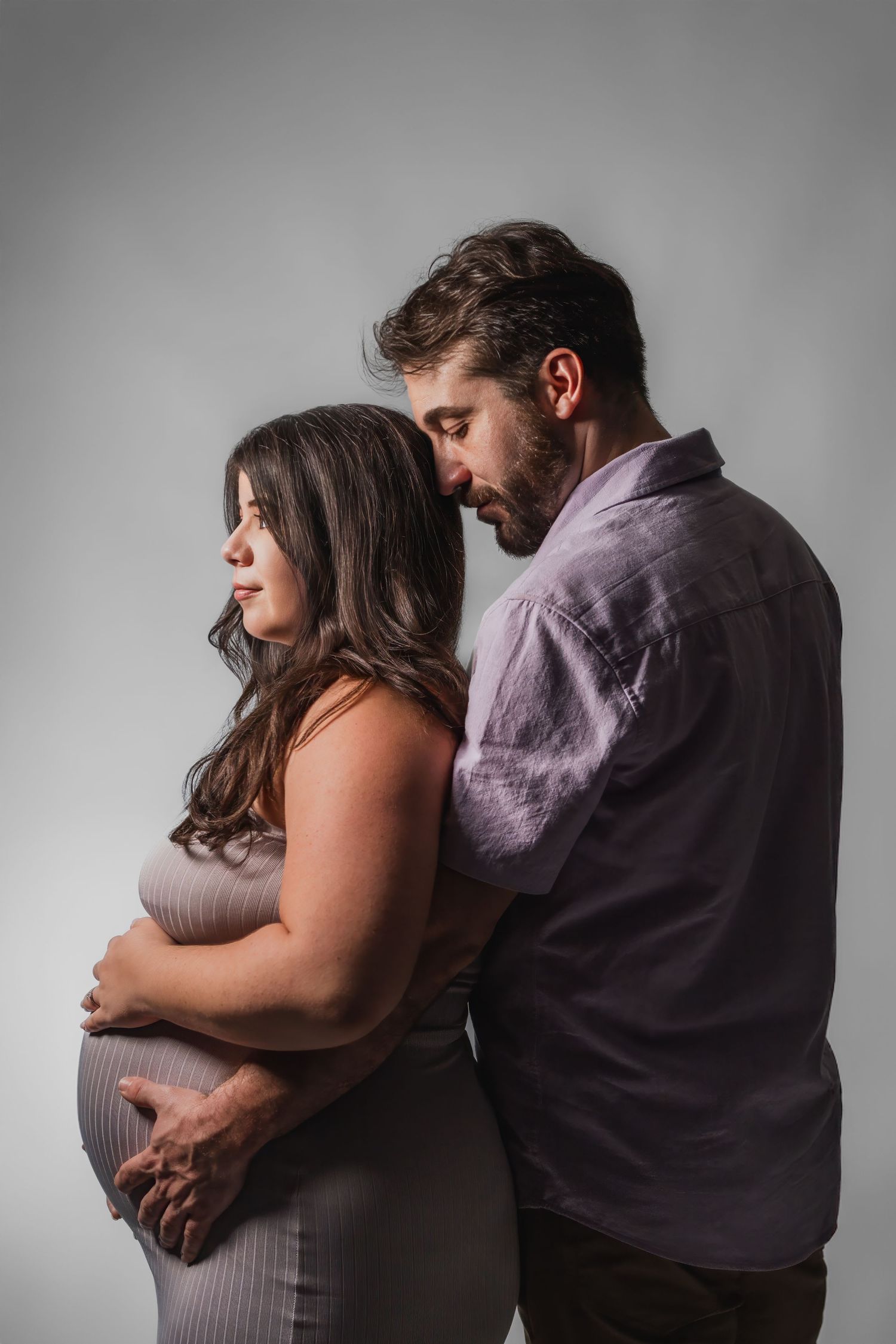 Studio maternity photos in South Florida by photographer, intimate couple portrait with soft lighting and timeless styling