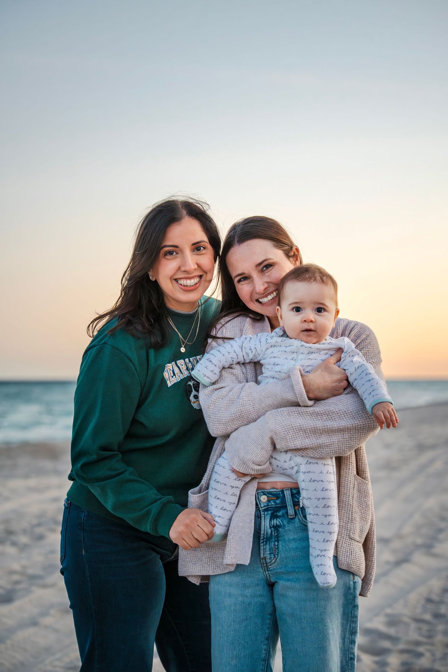 Beach family portrait of close friends holding a baby at sunset during a South Florida lifestyle photo session.