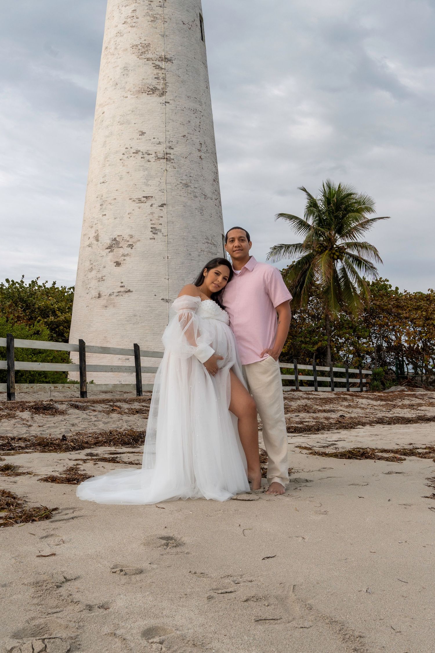 Scenic maternity session by the Cape Florida Lighthouse, with palm trees and ocean breeze enhancing the coastal vibe.