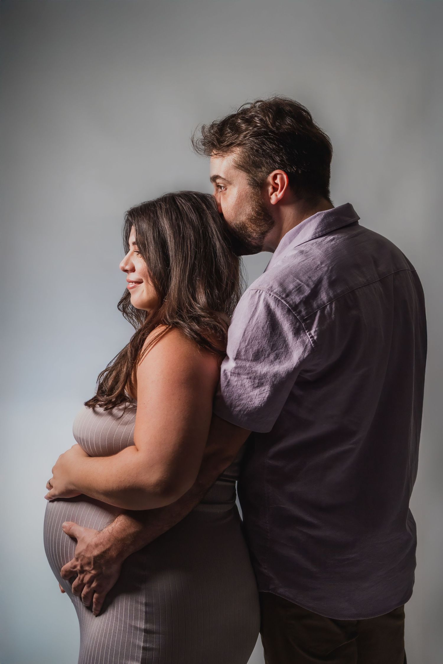 Couple embracing during intimate maternity studio session in South Florida