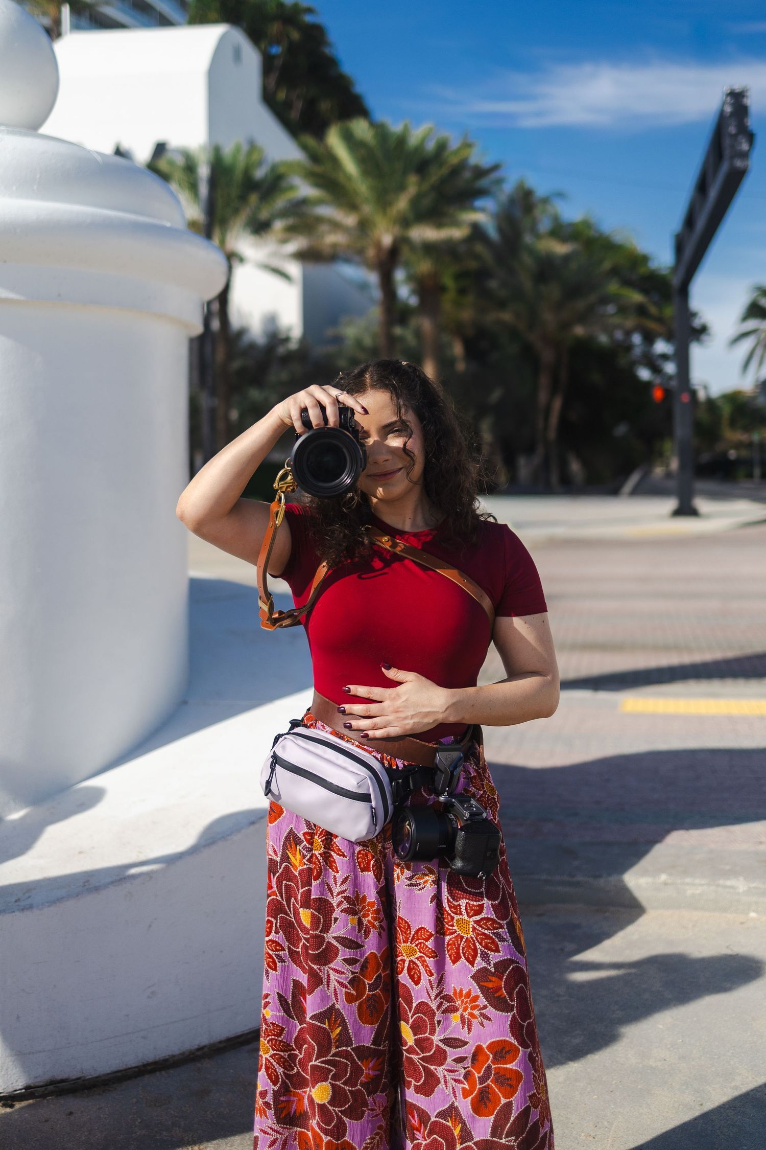 Behind-the-scenes photo of a South Florida photographer capturing portraits outdoors in natural light during a creative shoot.