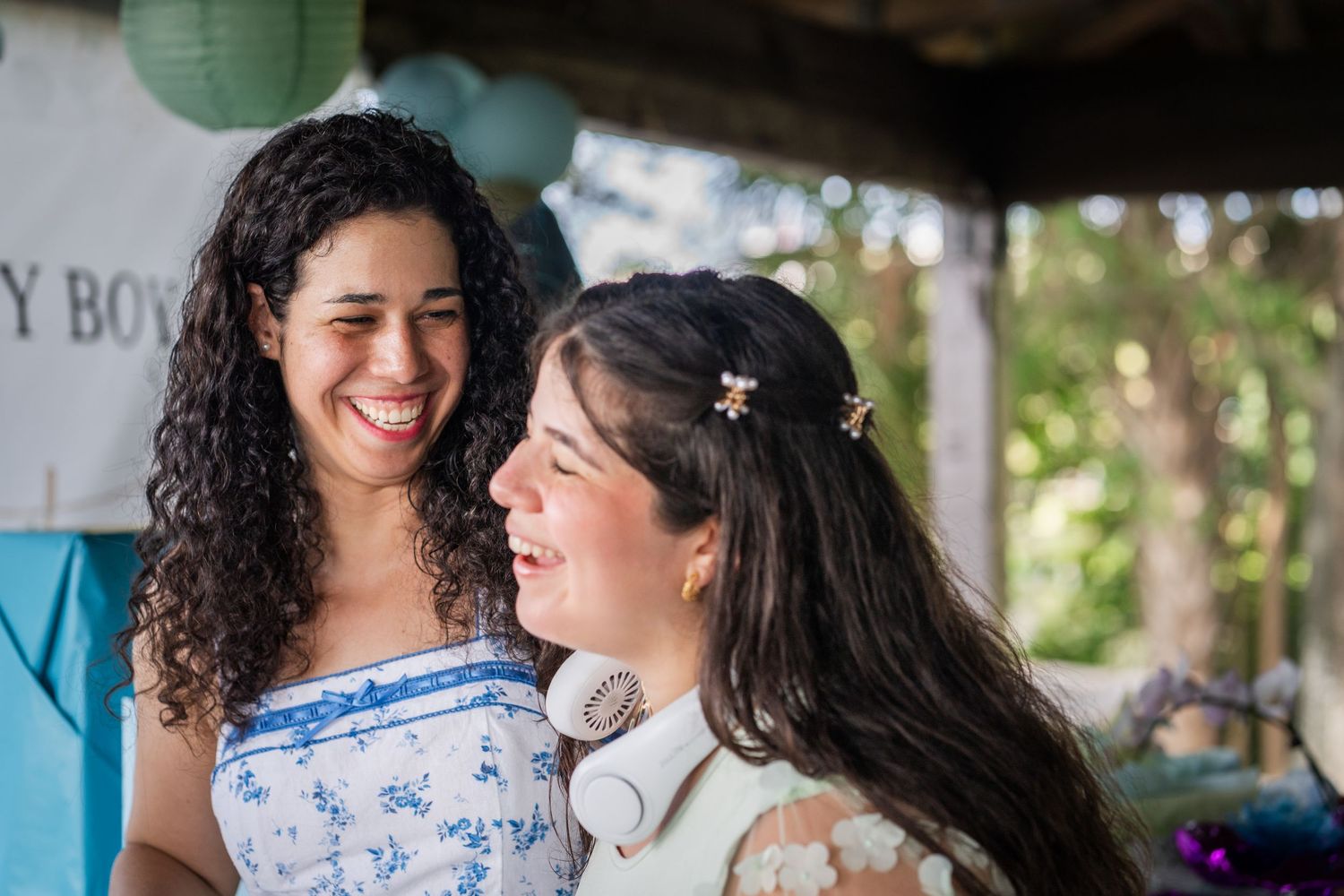 Siblings sharing a joyful moment at a baby shower, captured candidly with soft natural light in South Florida.