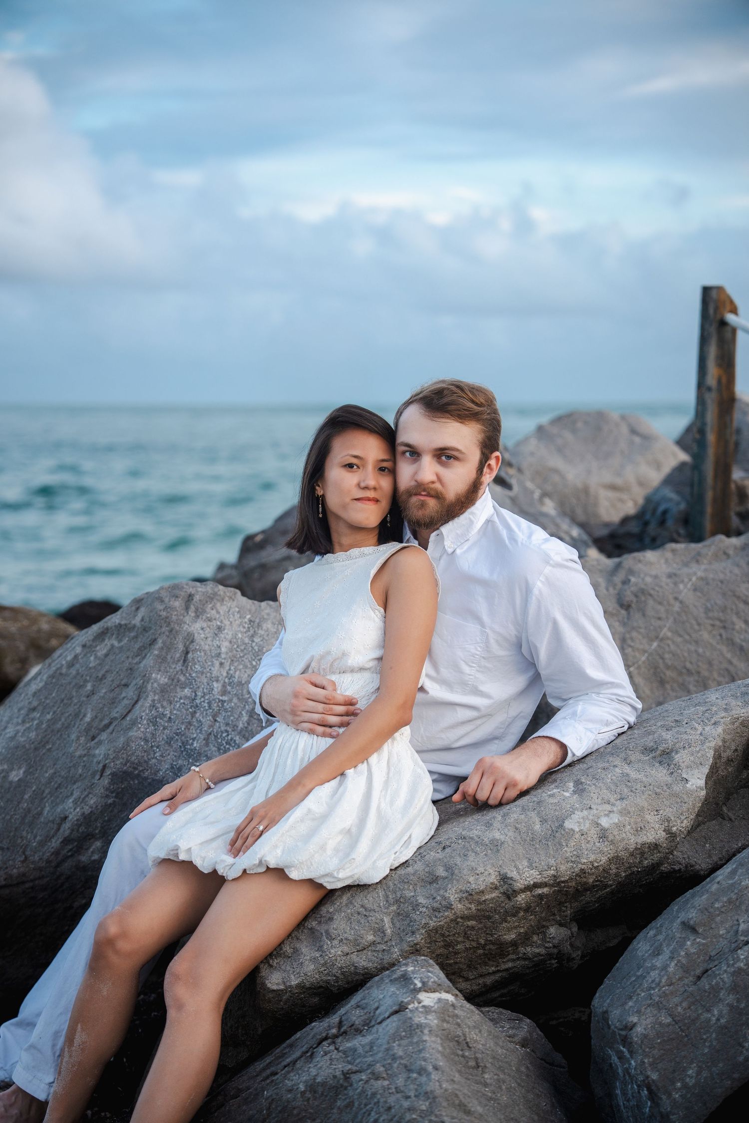 Couple portrait at Bill Baggs Cape Florida State Park, captured on the rocks near the lighthouse with a natural, documentary style.