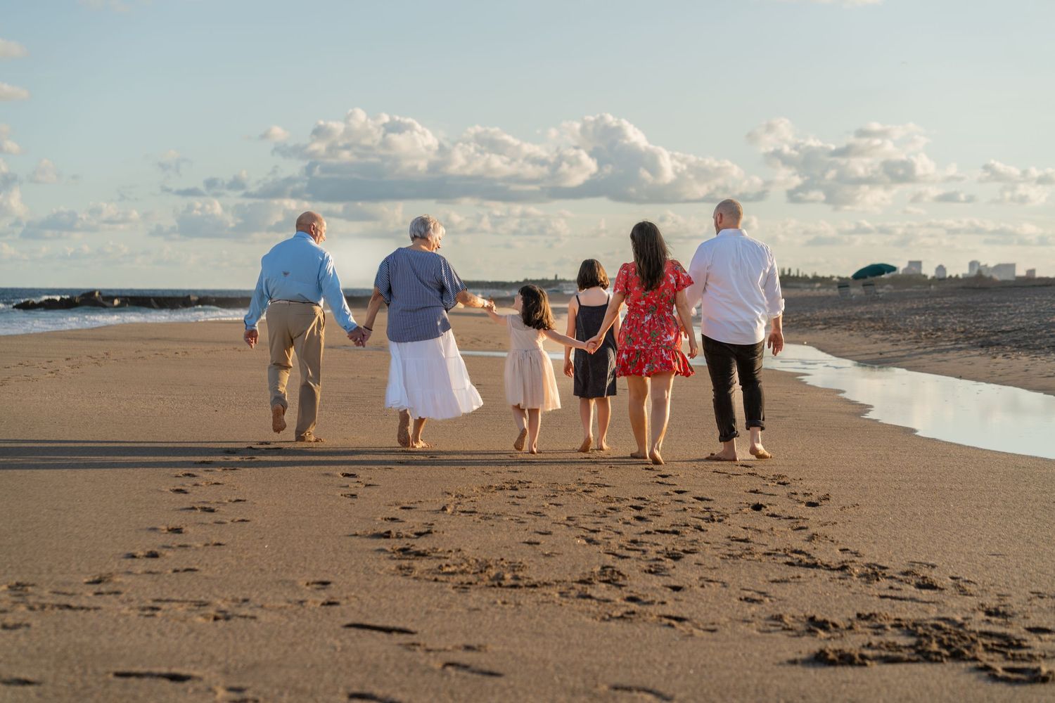 Family holiday photos on the beach in South Florida by photographer, natural light session with group walking along shoreline
